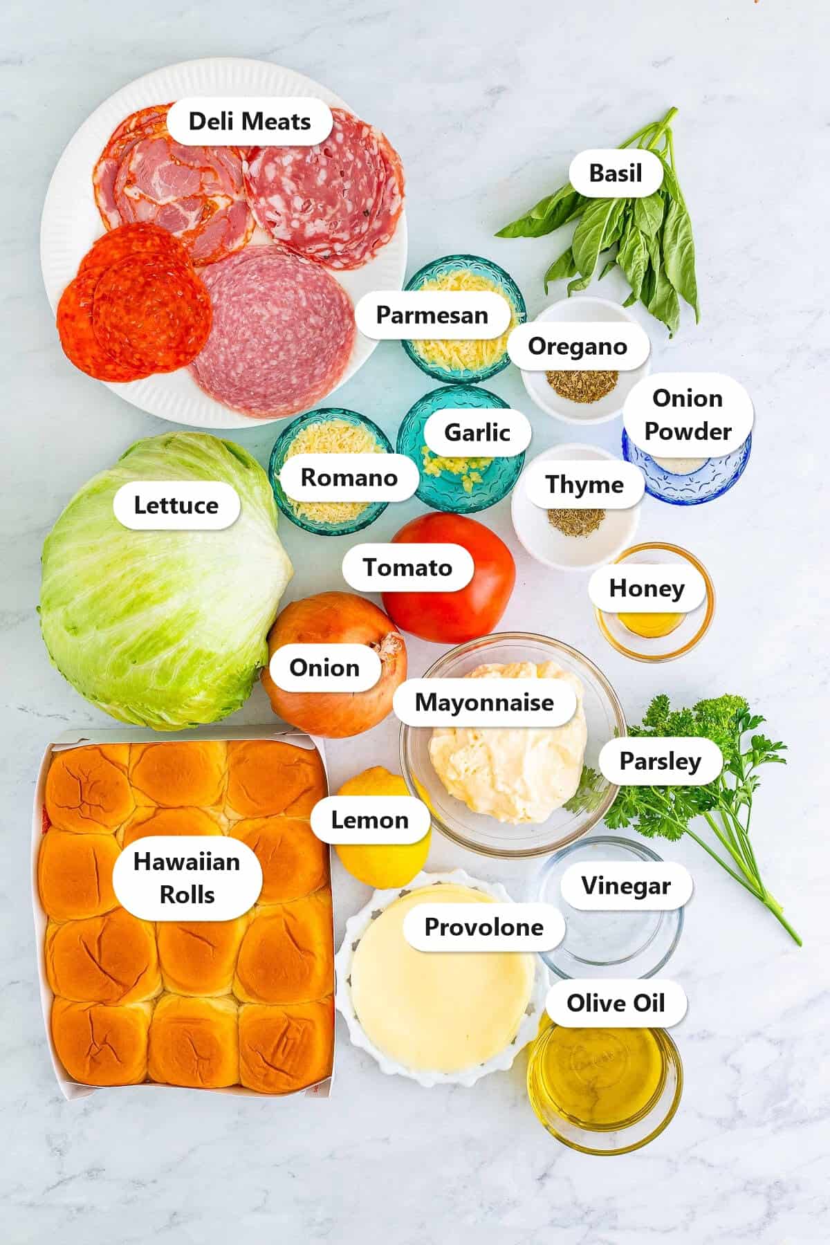 Labeled ingredients for Italian sliders including deli meats, provolone, Hawaiian rolls, lettuce, tomato, onion, and the homemade Italian dressing components.