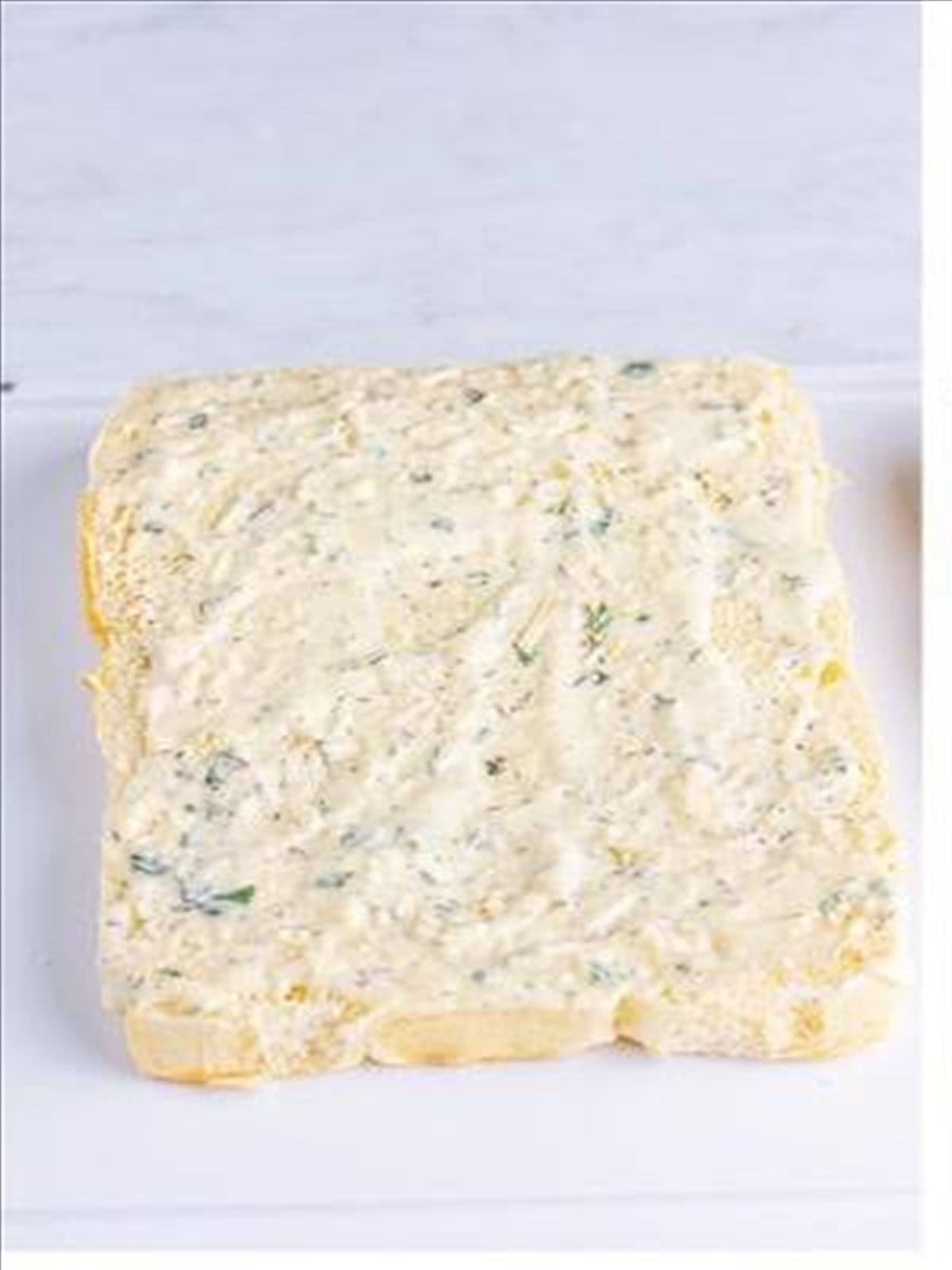 Italian dressing spread over the bottom of split Hawaiian rolls.