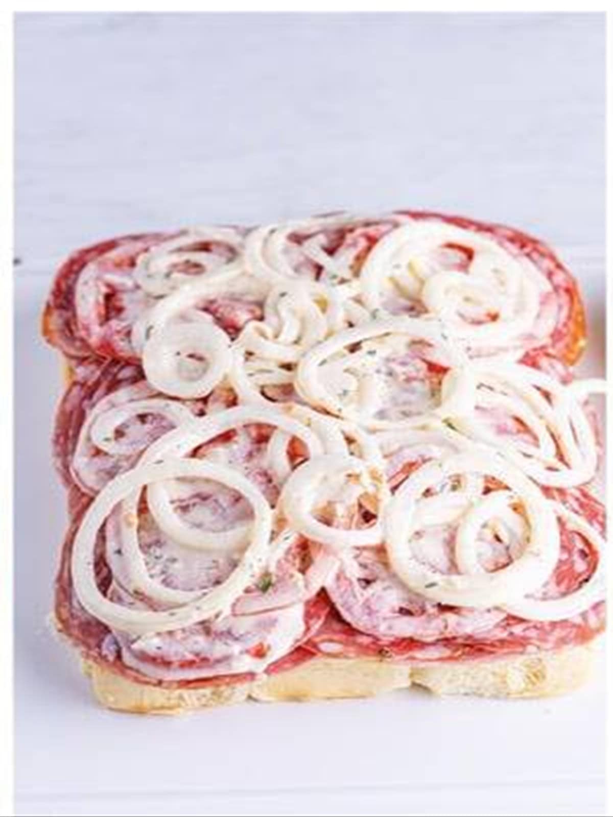 Dressed tomatoes and onions layered over the meats and cheese.