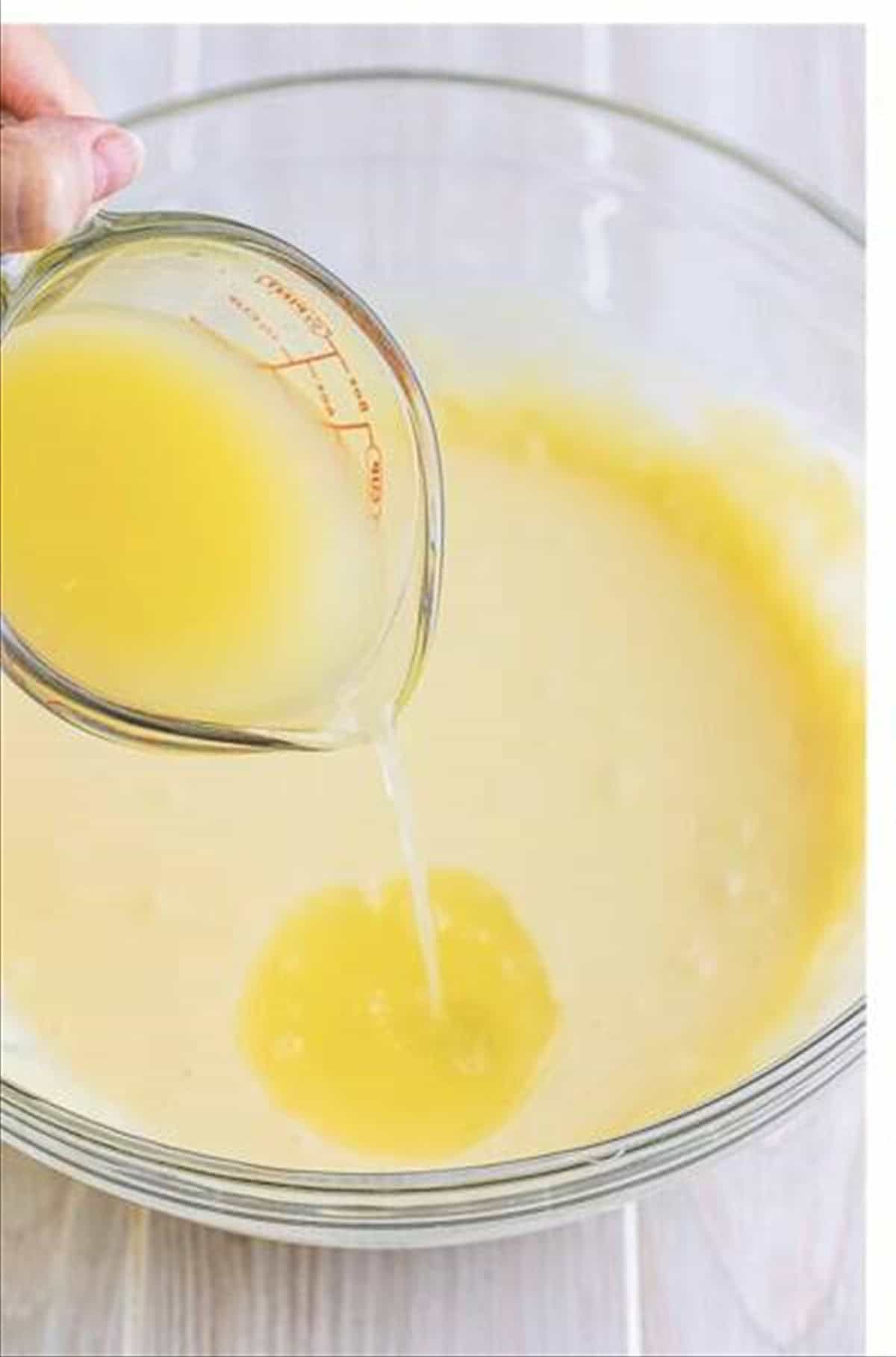 Key lime juice poured into cream cheese and condensed milk mixture for eclair cake.