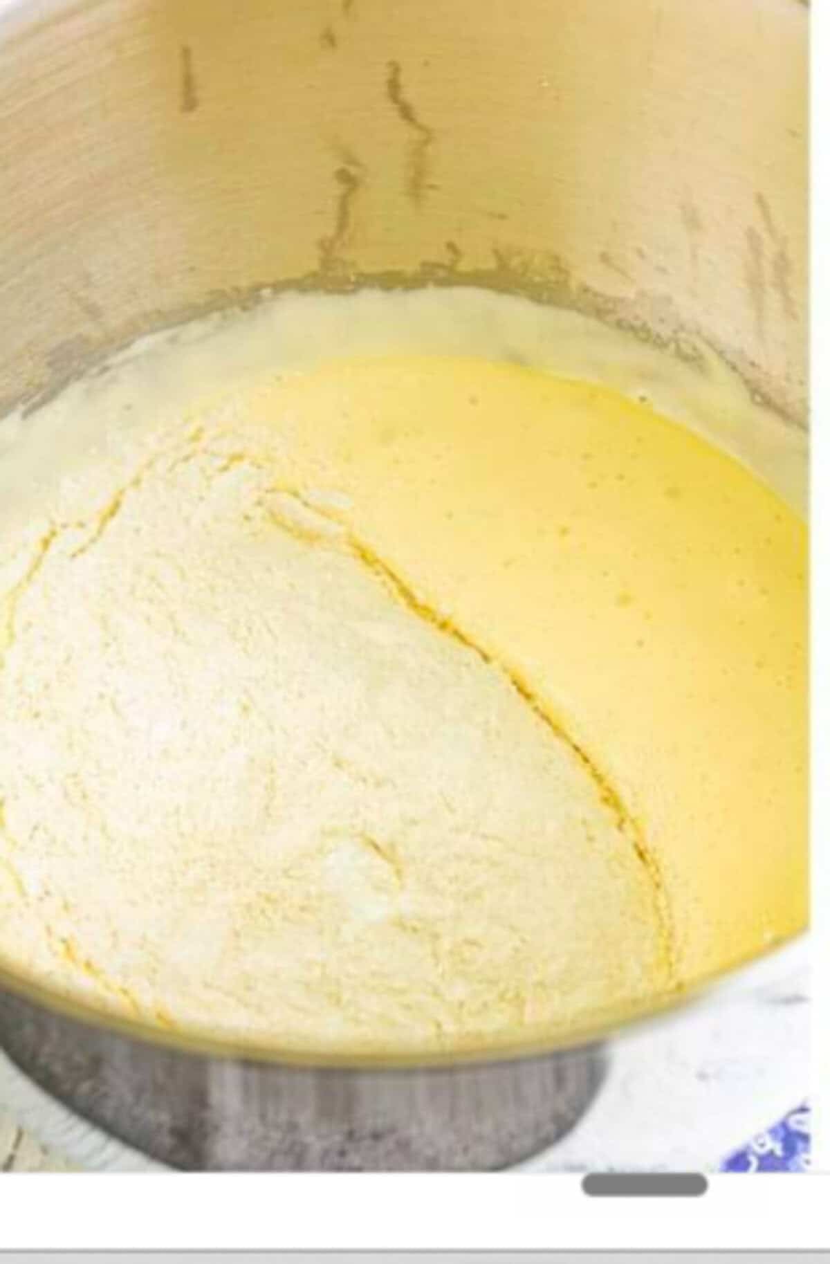 The warmed egg and sugar mixture transferred to a stand mixer bowl with the whisk attachment ready to whip for the Homemade Lady Finger Cookies Recipe.