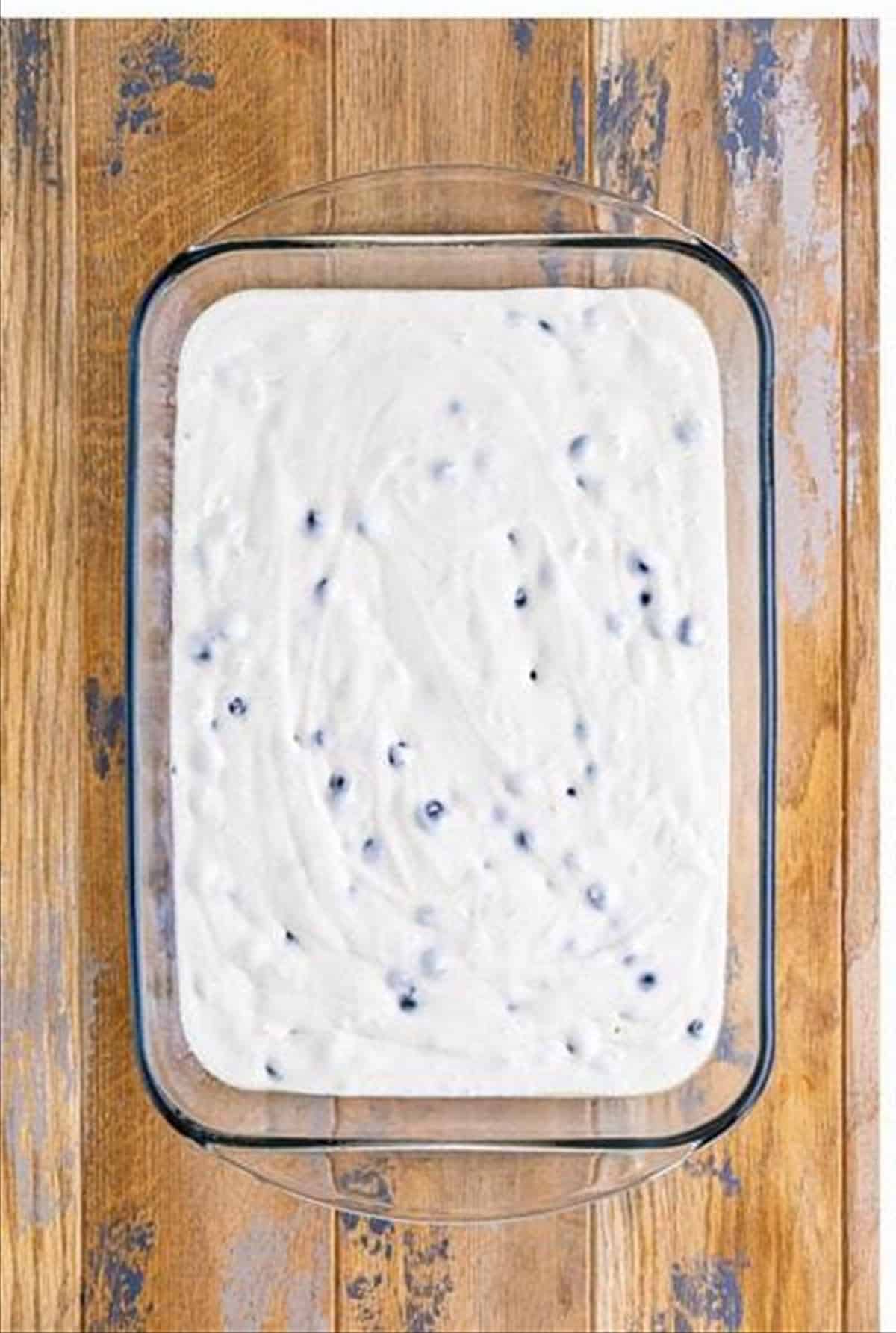 Lemon blueberry cake batter poured into a 9 by 13 baking dish.