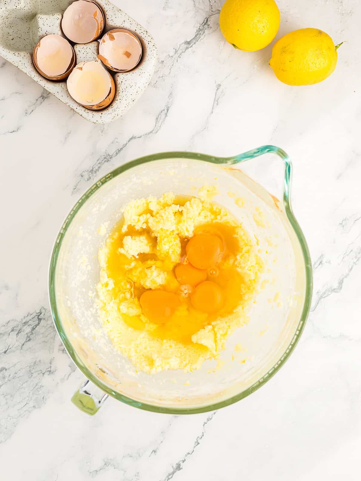 Adding eggs, lemon juice, and vanilla to the lemon cake batter.
