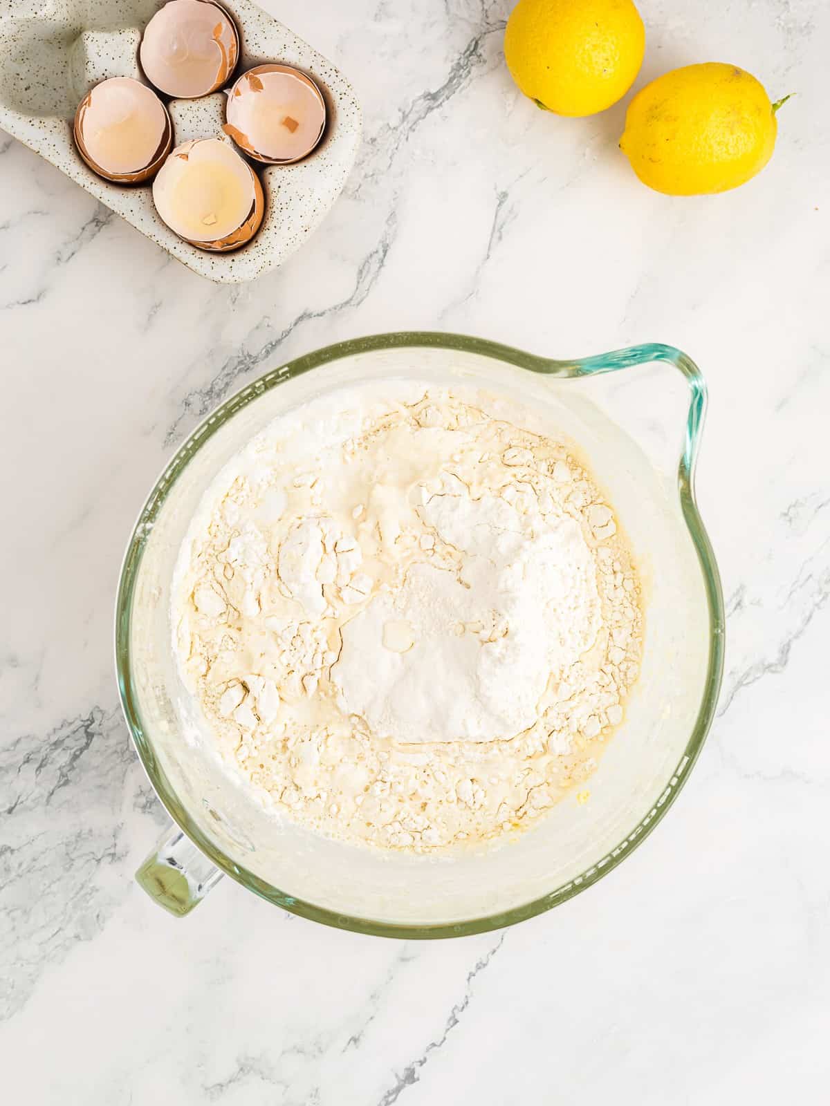 Adding flour, baking powder, and milk to the lemon cake batter.