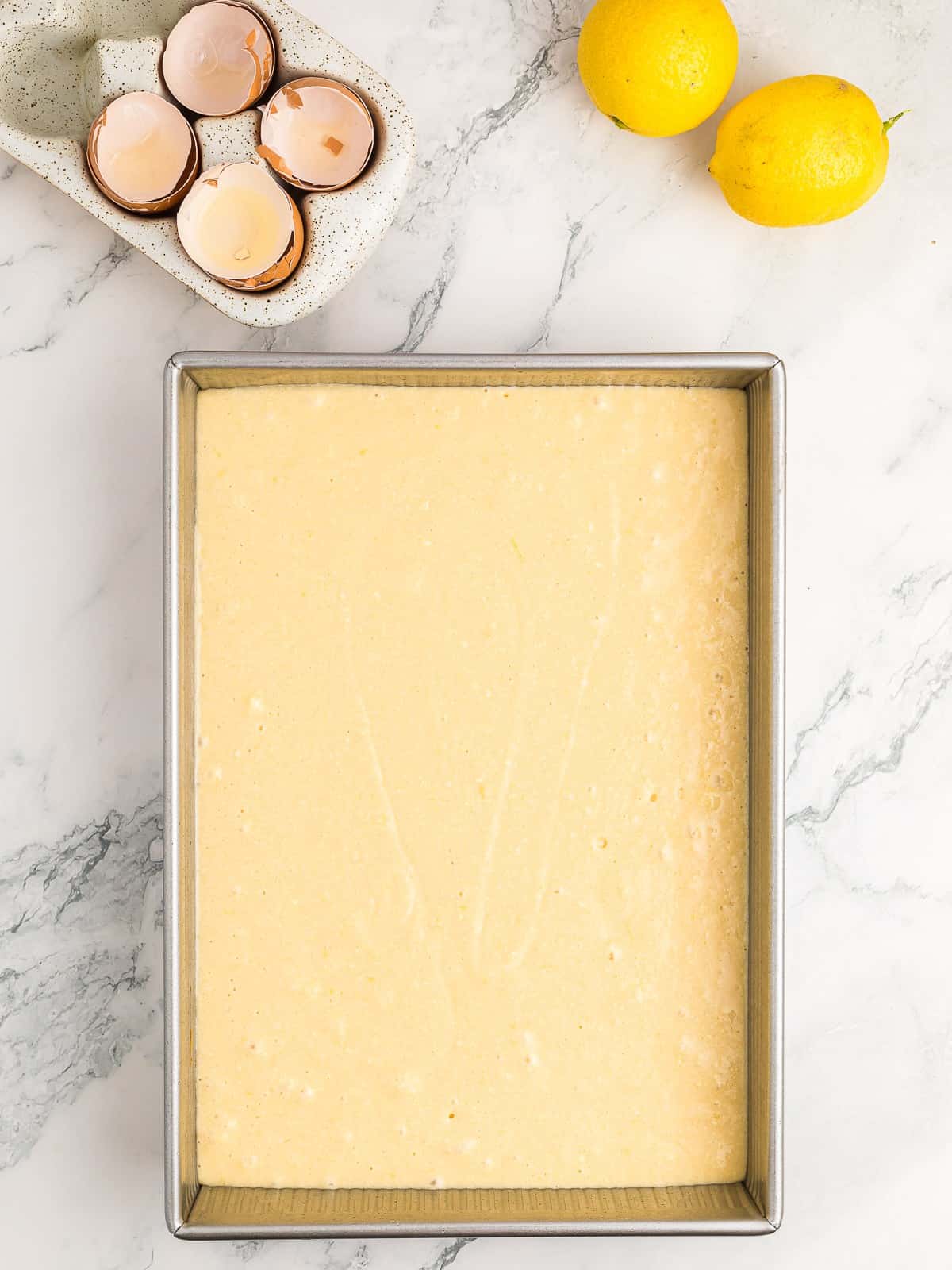 Lemon cake batter poured into a 9 by 13 baking pan.