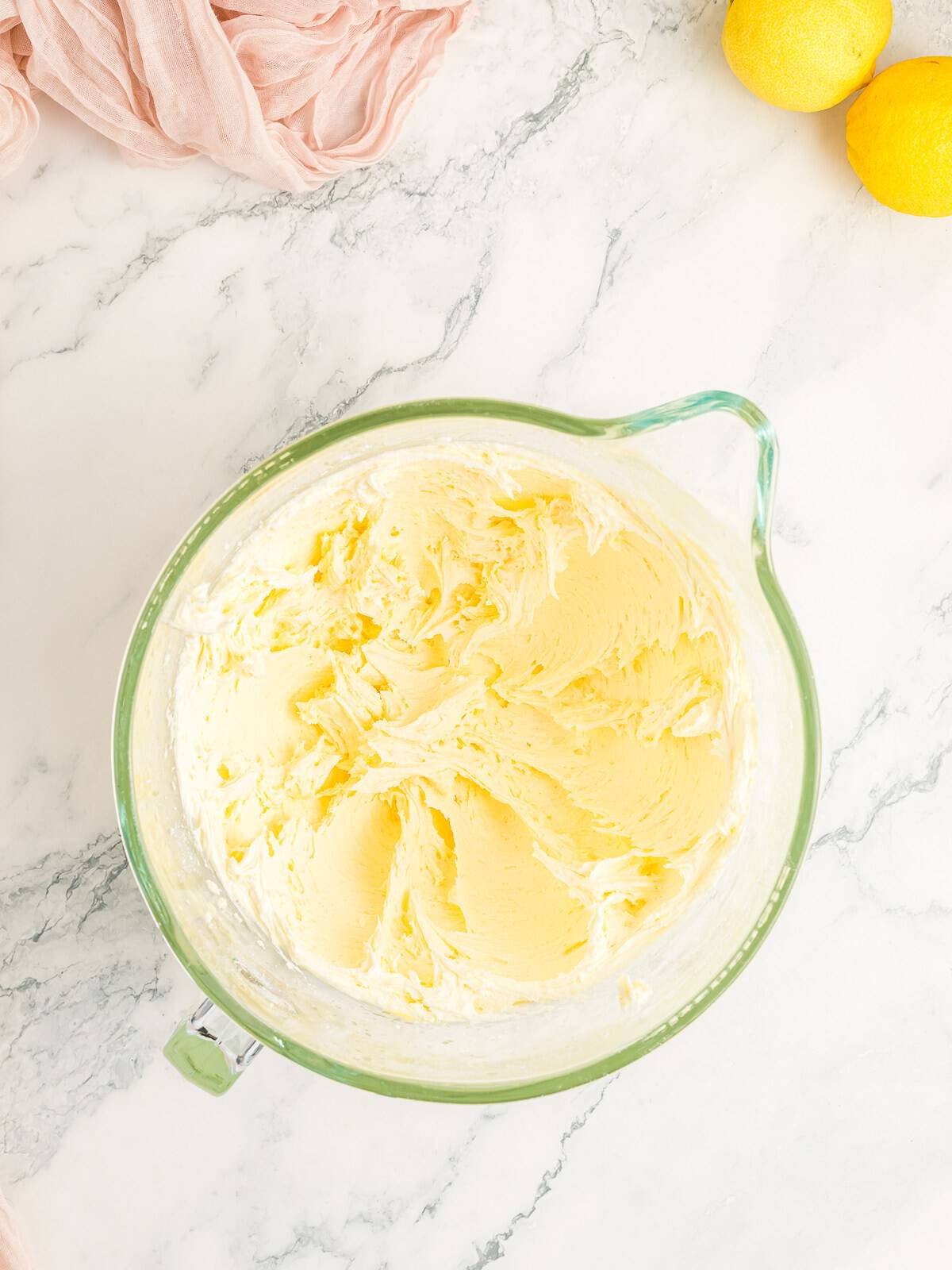 Whipped lemon buttercream frosting ready to spread on the lemon cake.