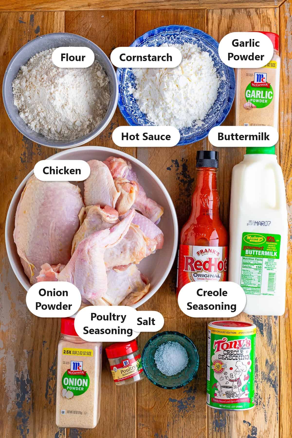 Labeled ingredients for Louisiana fried chicken including chicken, flour, cornstarch, buttermilk, hot sauce, and creole seasoning.