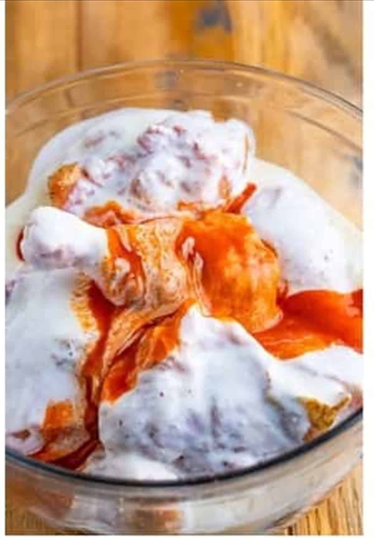 Buttermilk and hot sauce poured over the seasoned chicken for the Louisiana fried chicken marinade.