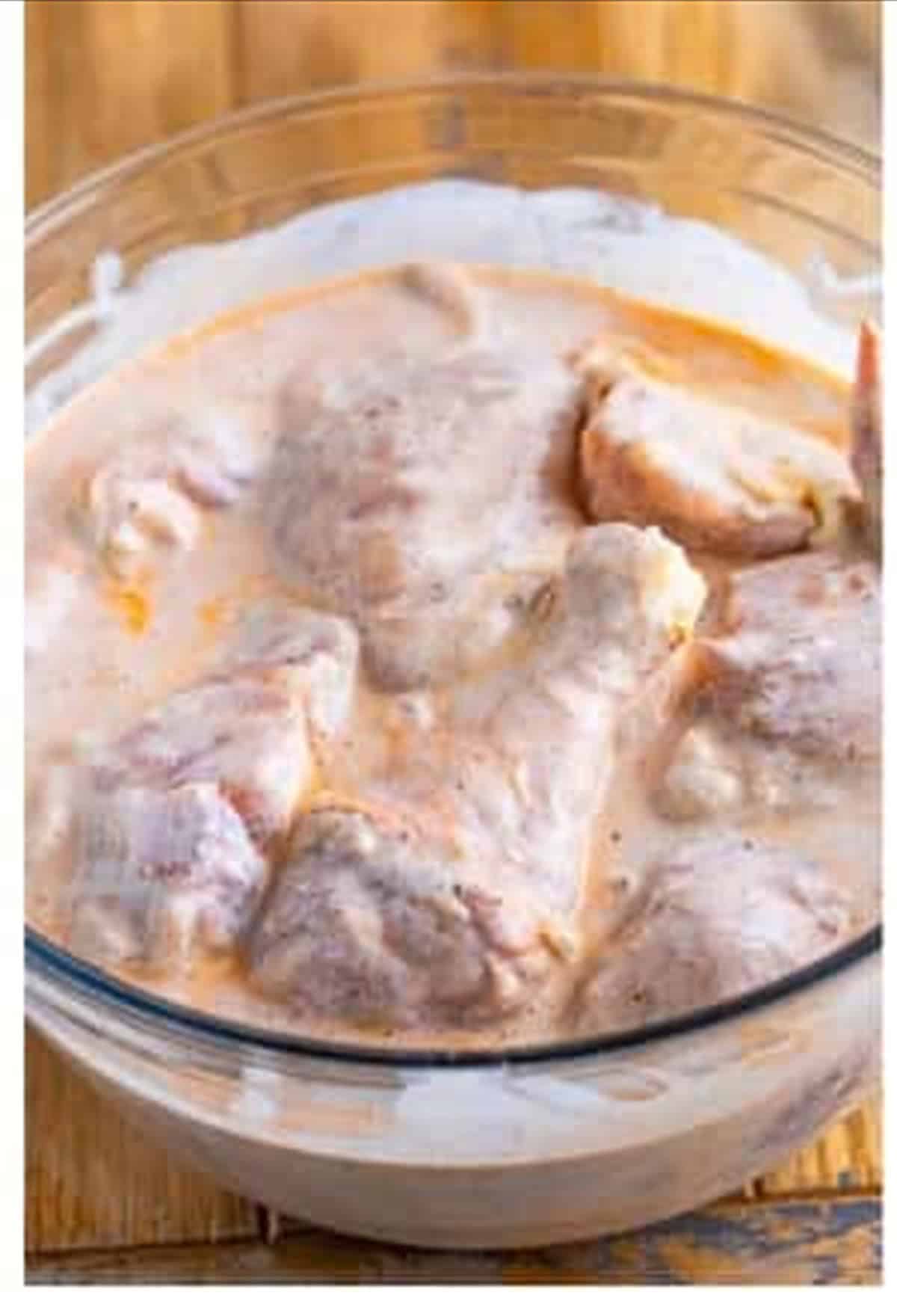Chicken pieces fully coated in the buttermilk and hot sauce marinade before chilling.