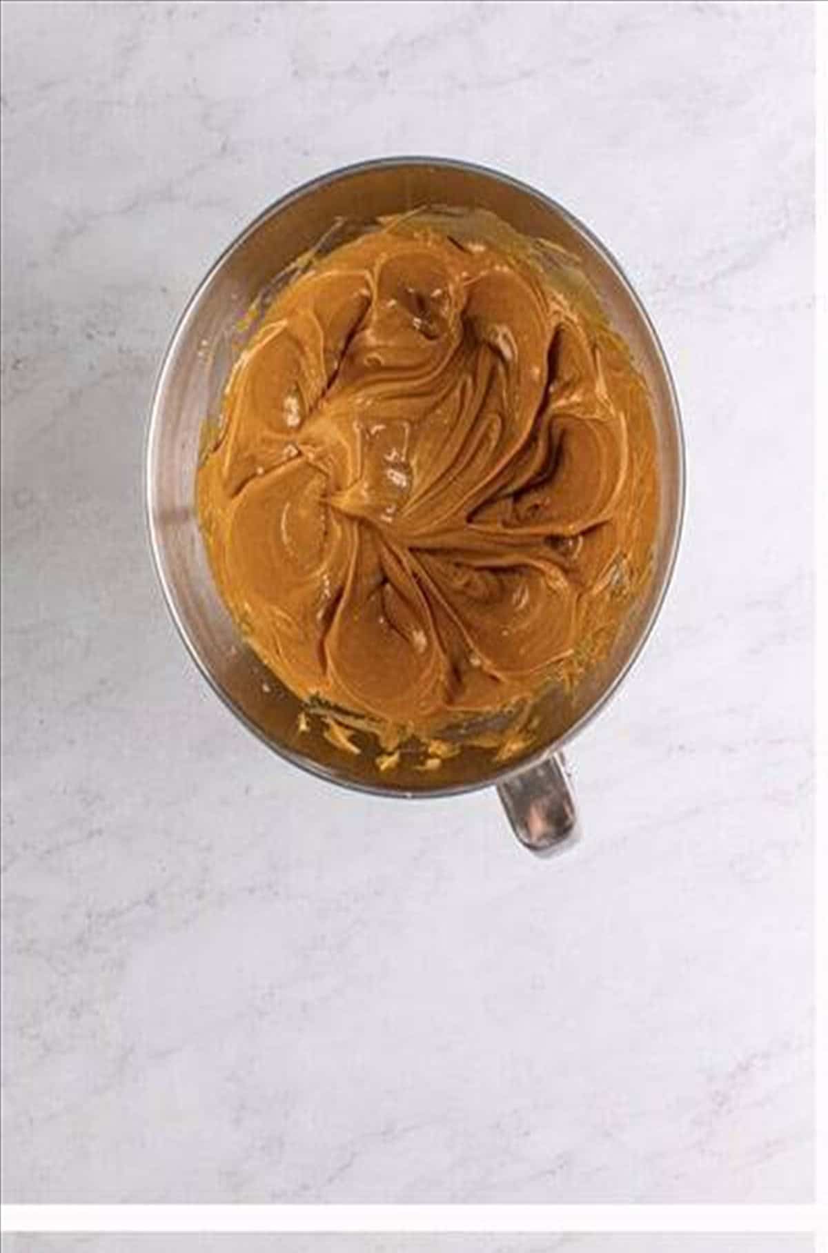 Creamy peanut butter and softened butter creamed in a stand mixer bowl.