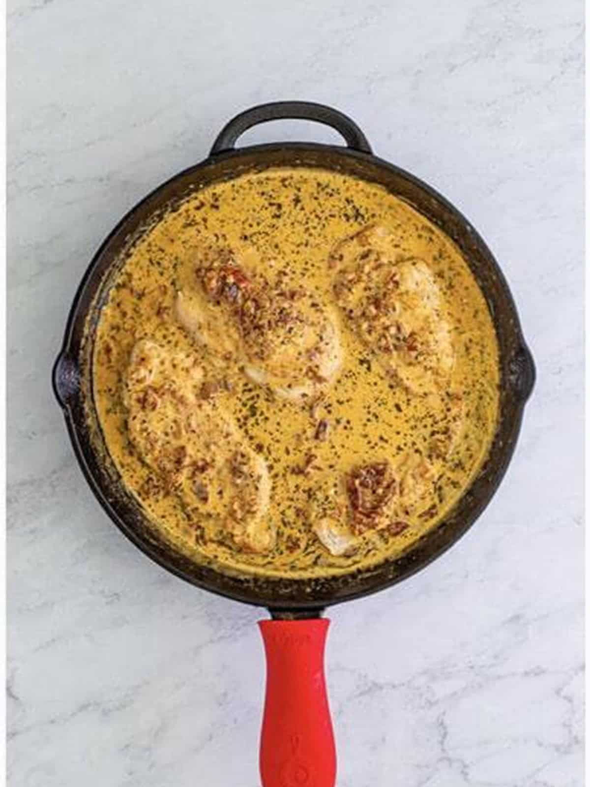 Returning seared chicken to the creamy sauce for Marry Me Chicken.