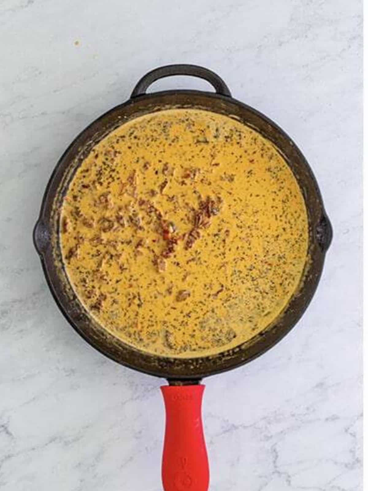 Simmering the creamy sundried tomato sauce for Marry Me Chicken.