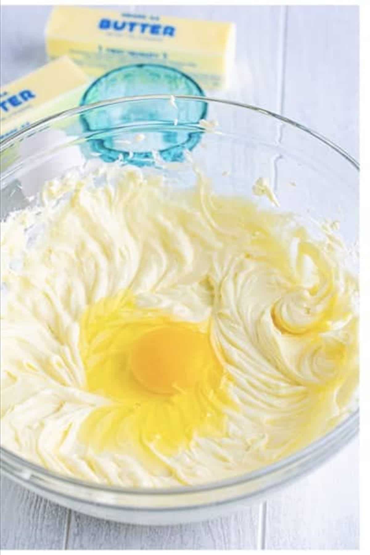 Sour cream, pineapple juice, and vanilla extract being added to the cream cheese batter for Copycat Pineapple Upside Down Cheesecake.