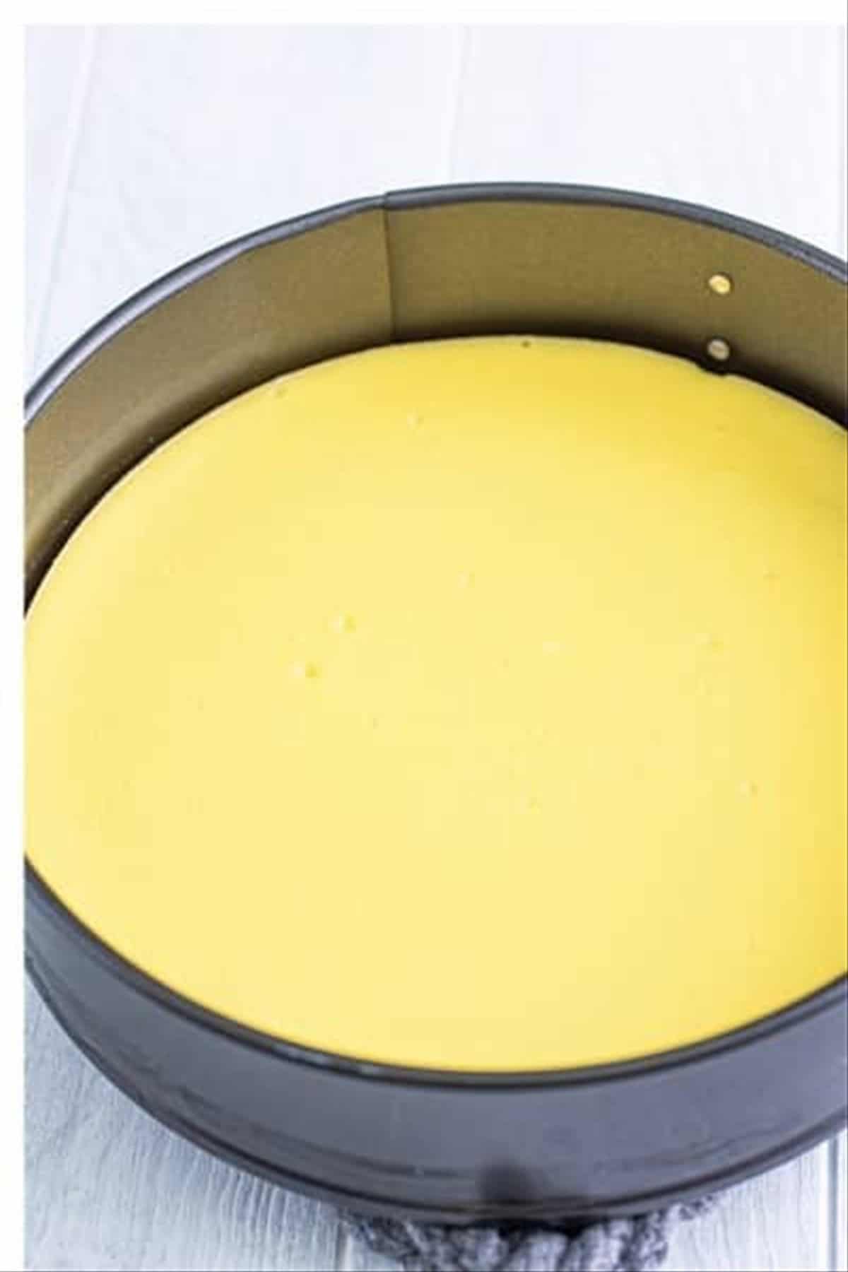 Baked pineapple cheesecake cooled to room temperature in the springform pan ready for assembly.