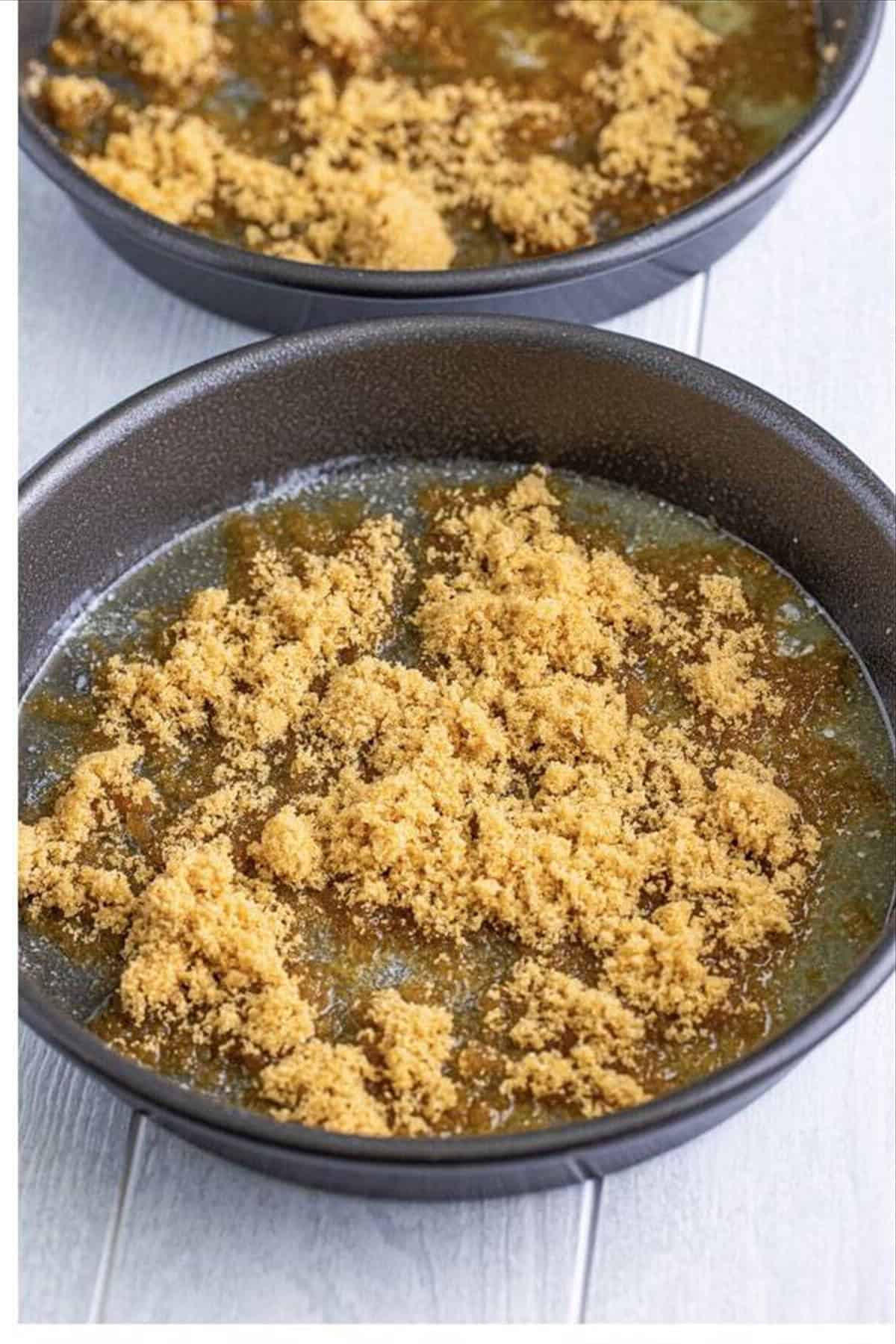 Brown sugar sprinkled evenly over the melted butter in the cake pans for the caramel topping base.