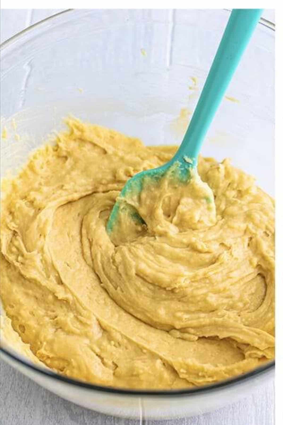 Pineapple Upside Down Cake batter divided evenly between two 9-inch cake pans on top of the brown sugar pineapple topping layer.