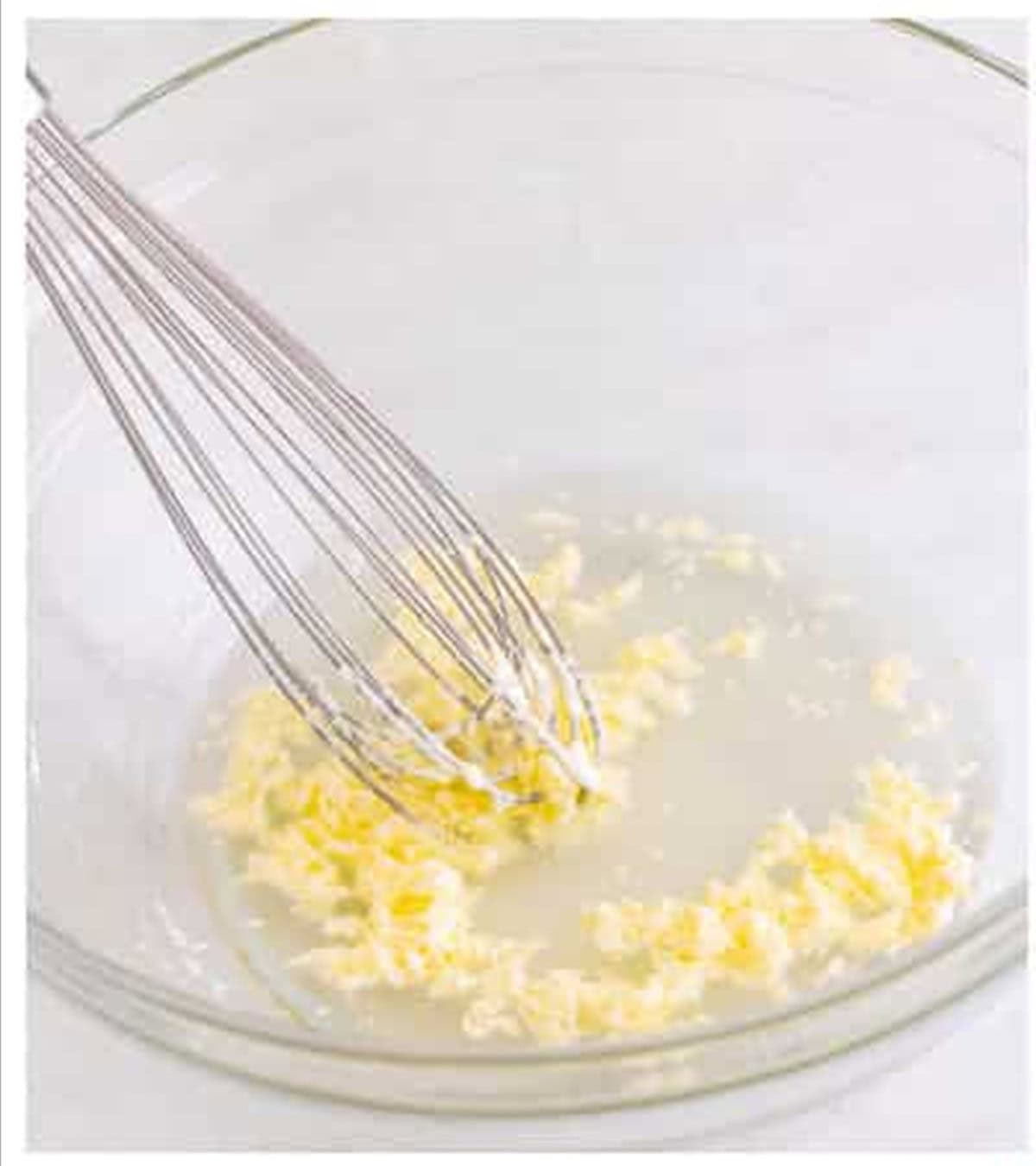 Whisking the butter and water mixture in a glass bowl for Pizza Hut cheese sticks.