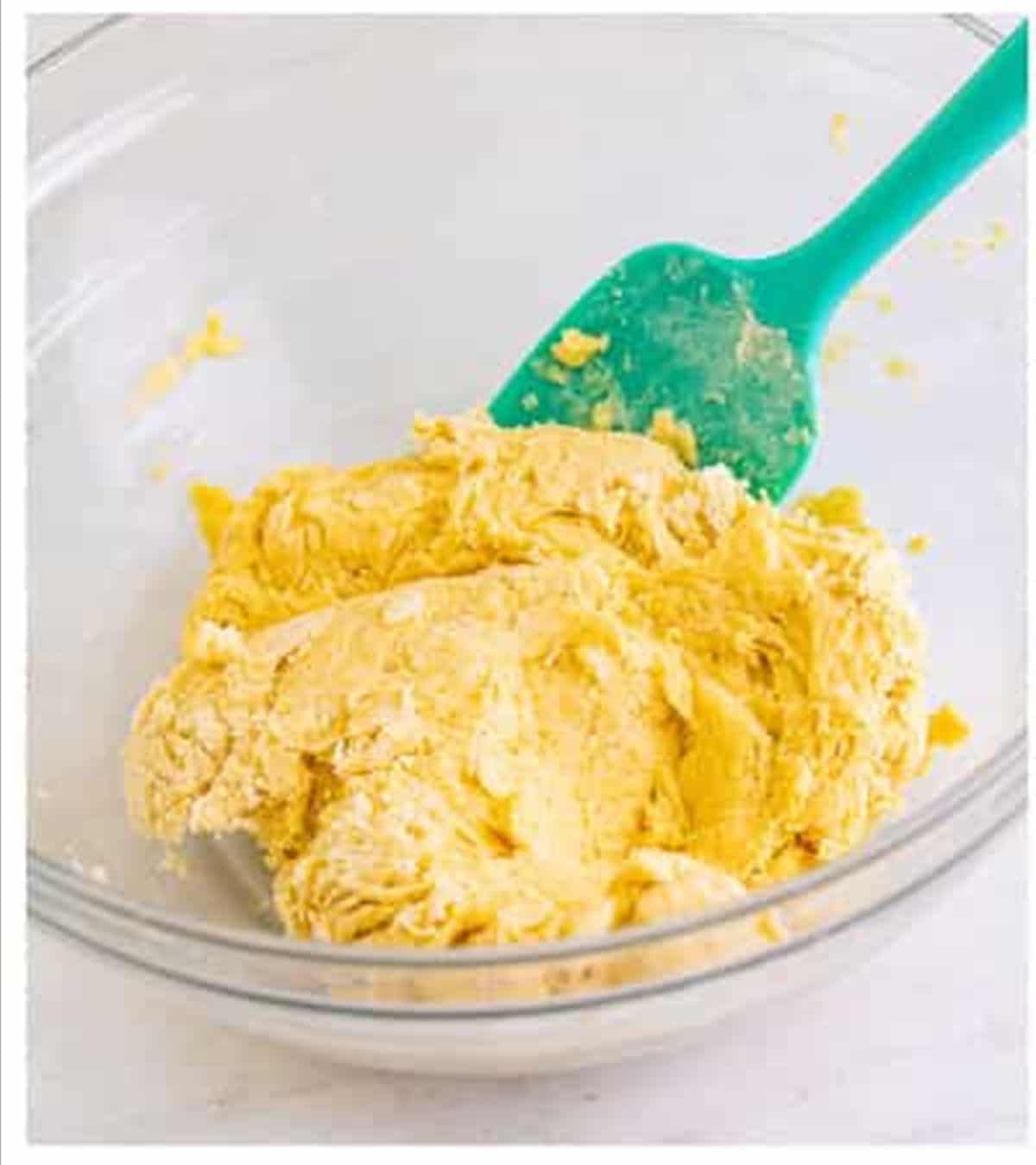Cheese sticks dough stirred together until just combined in a glass bowl.