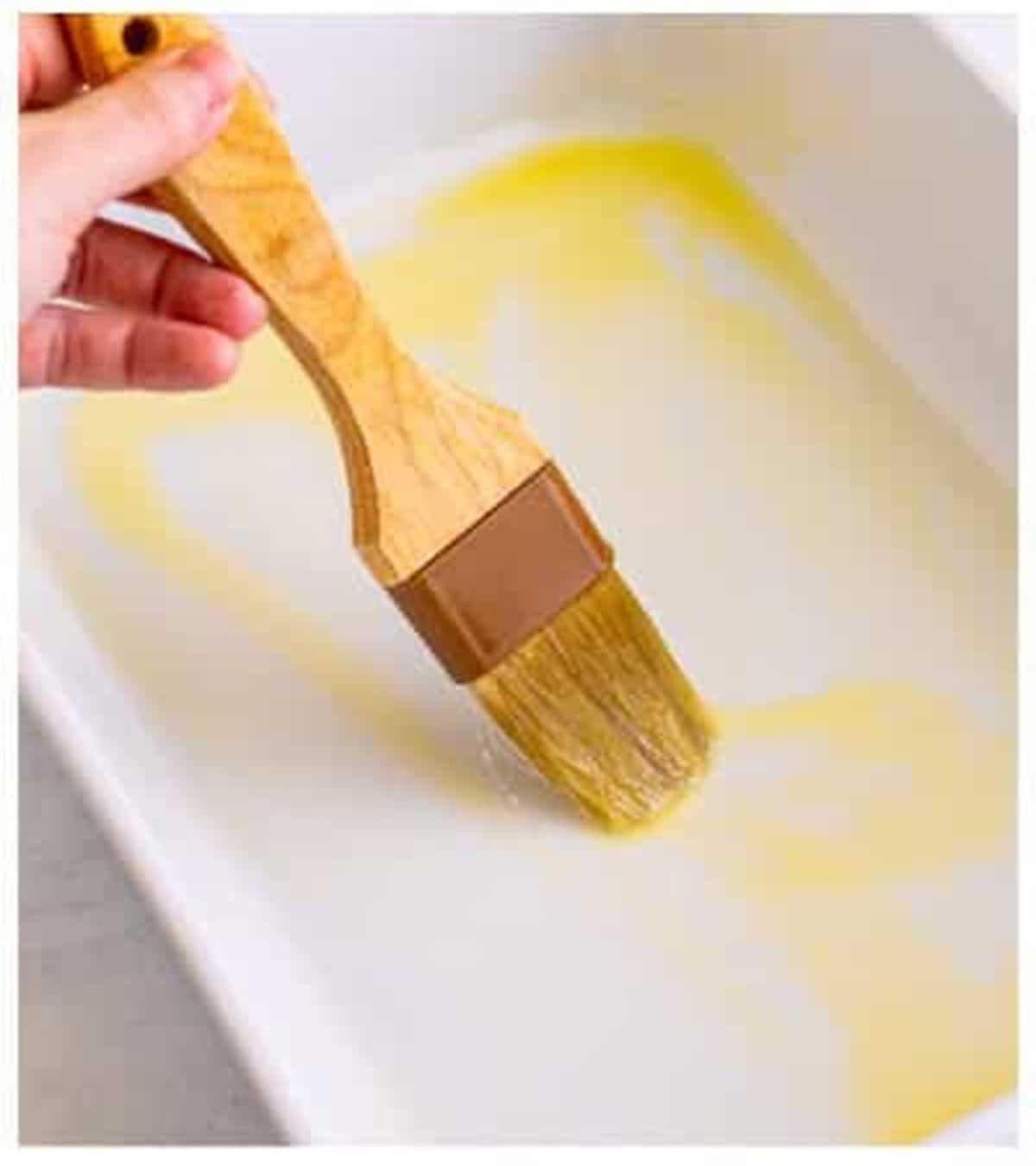 Brushing melted butter into a white baking dish for Pizza Hut cheese sticks.