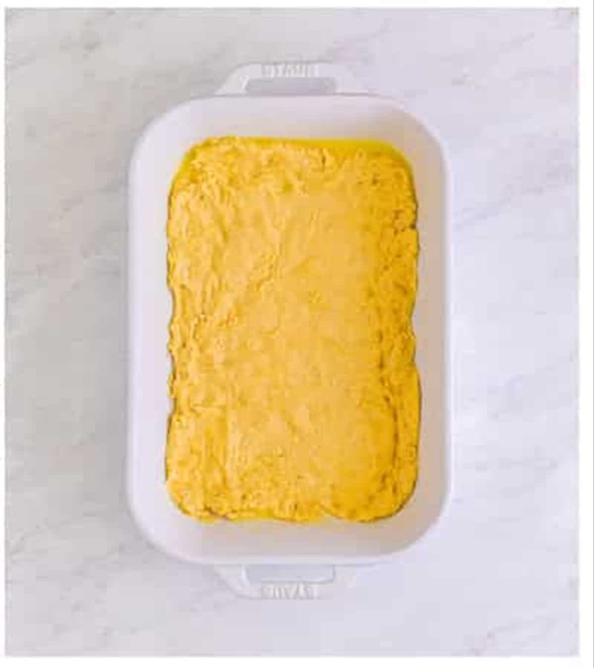 Cheese sticks dough spread evenly into the buttered baking dish.