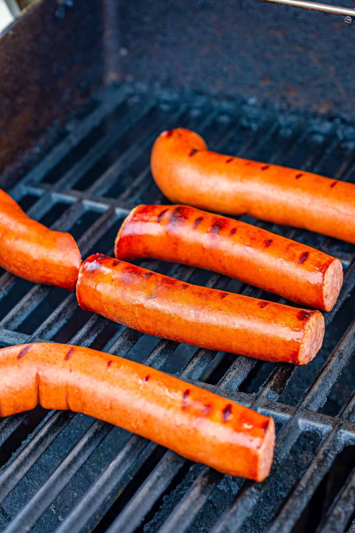 Polish sausages placed in a single layer on a hot grill for the Polish Sausage Sandwich Recipe.