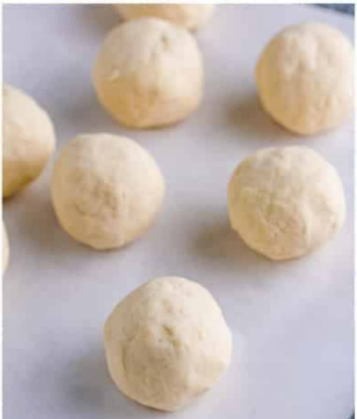 Pupusa dough divided into eight equal portions on a counter for a Pupusas Recipe.