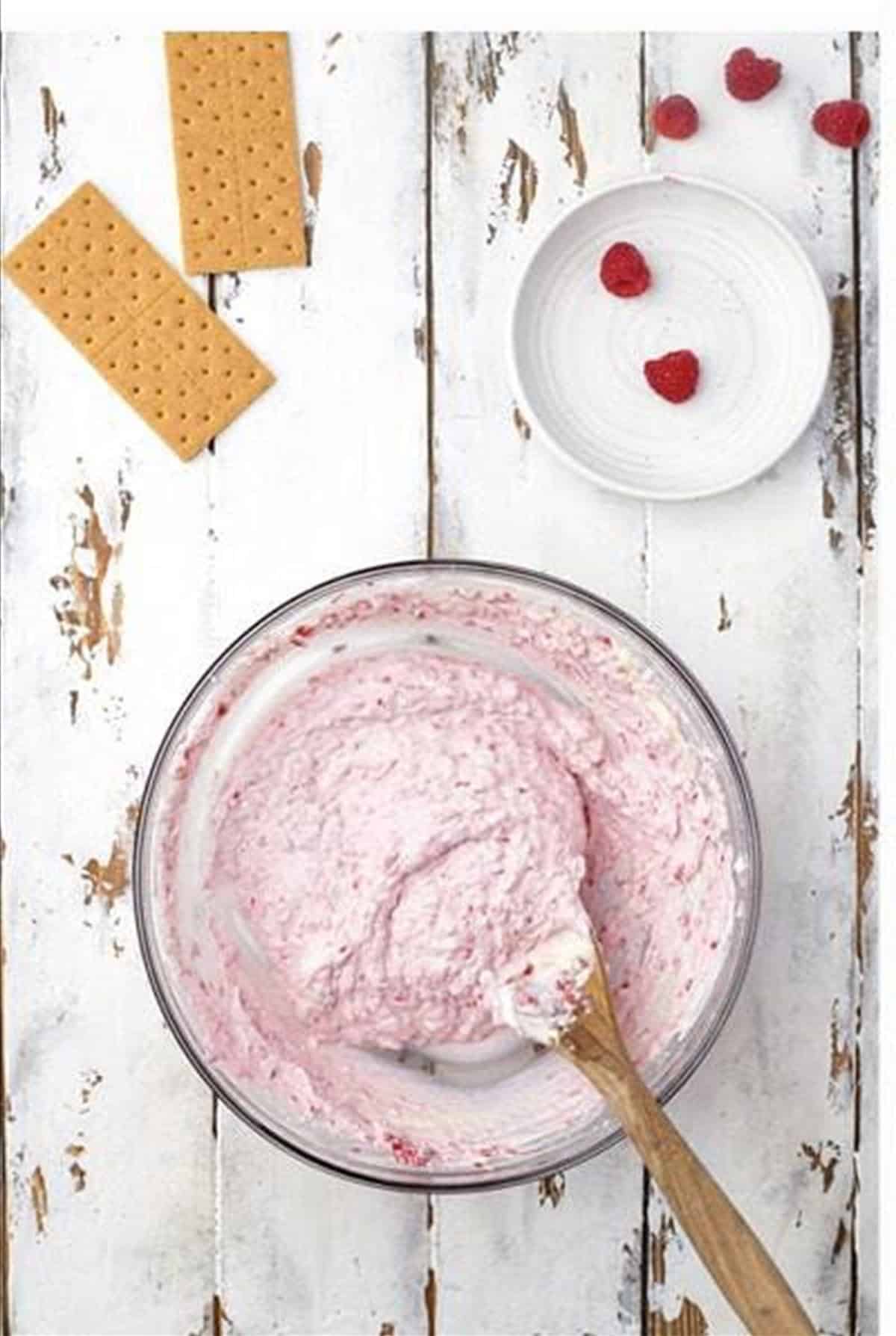 Raspberries stirred into the pink cheesecake filling.