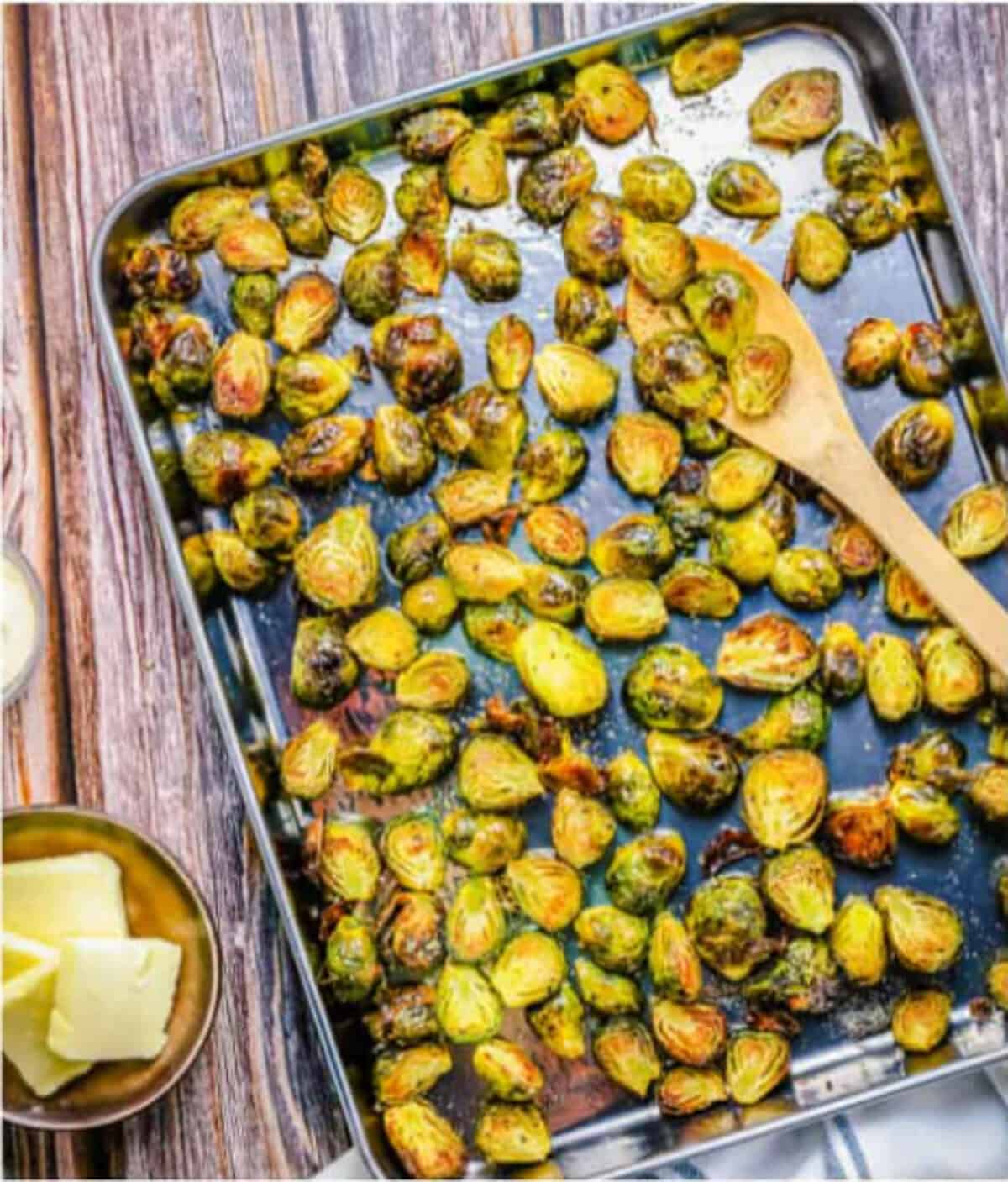 Brussel sprouts in the middle of roasting in the oven at 375 degrees, golden brown on the cut sides and vibrant green on top for the Easy Oven Roasted Brussel Sprouts Recipe.