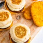 A homemade Sausage Egg McMuffin Recipe sandwich with melted American cheese, sausage patty, and round egg on a toasted English muffin.