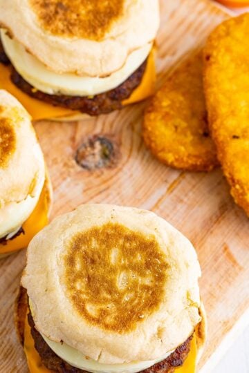 A homemade Sausage Egg McMuffin Recipe sandwich with melted American cheese, sausage patty, and round egg on a toasted English muffin.