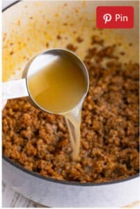 Whisking the roux for Sausage Rice Recipe until medium to dark brown.
