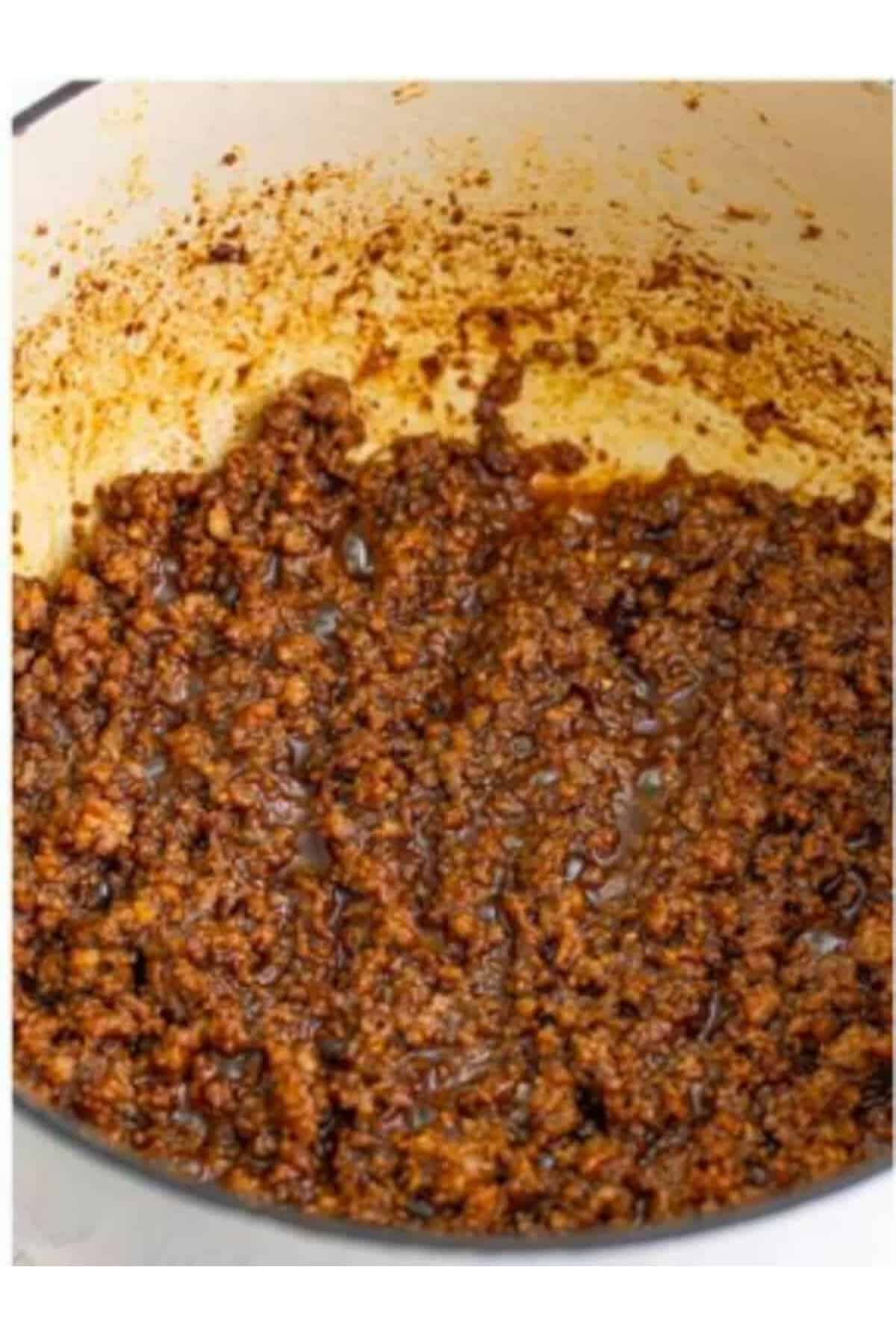 Adding minced garlic to the sausage mixture for Sausage Rice Recipe.