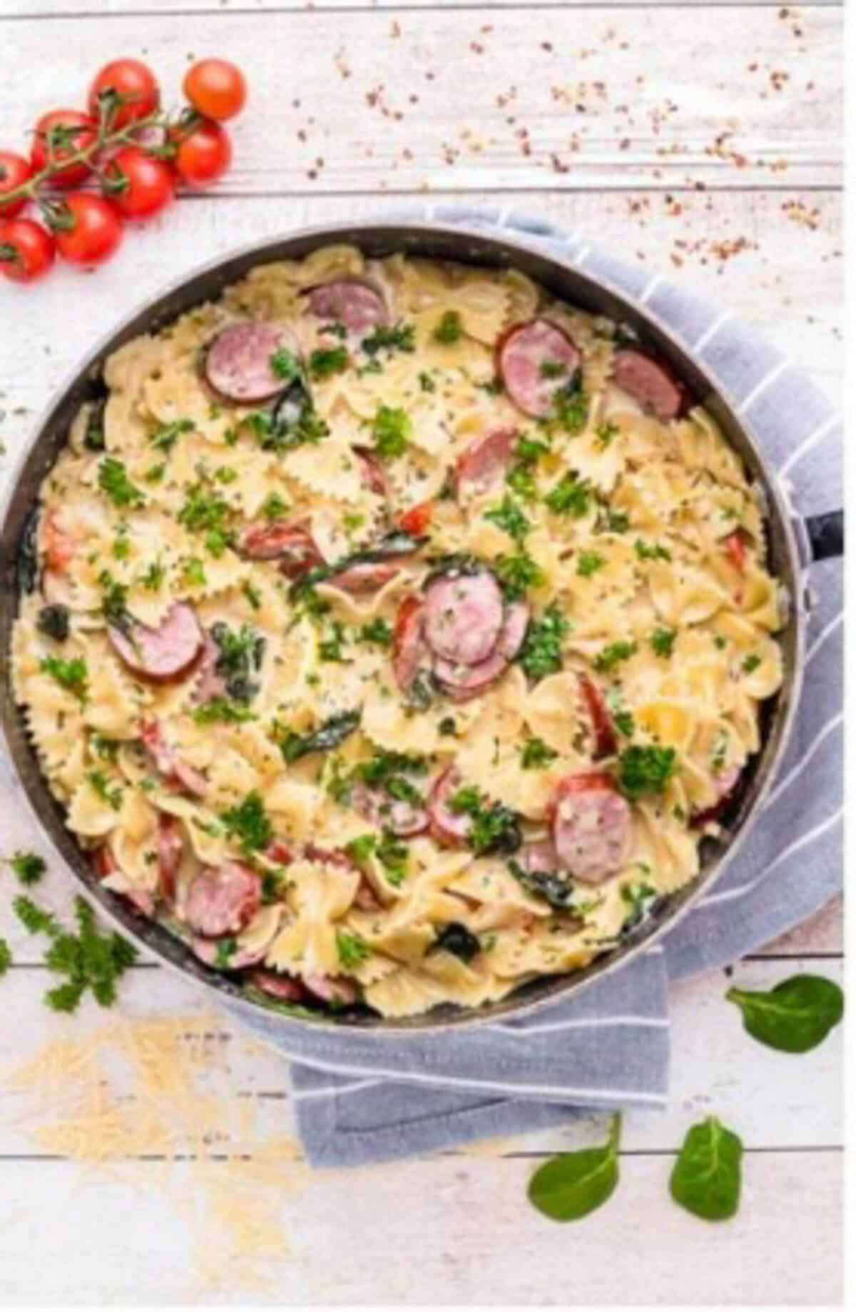 Fresh lemon being squeezed over the Creamy Kielbasa Pasta in the pot to brighten the sauce.