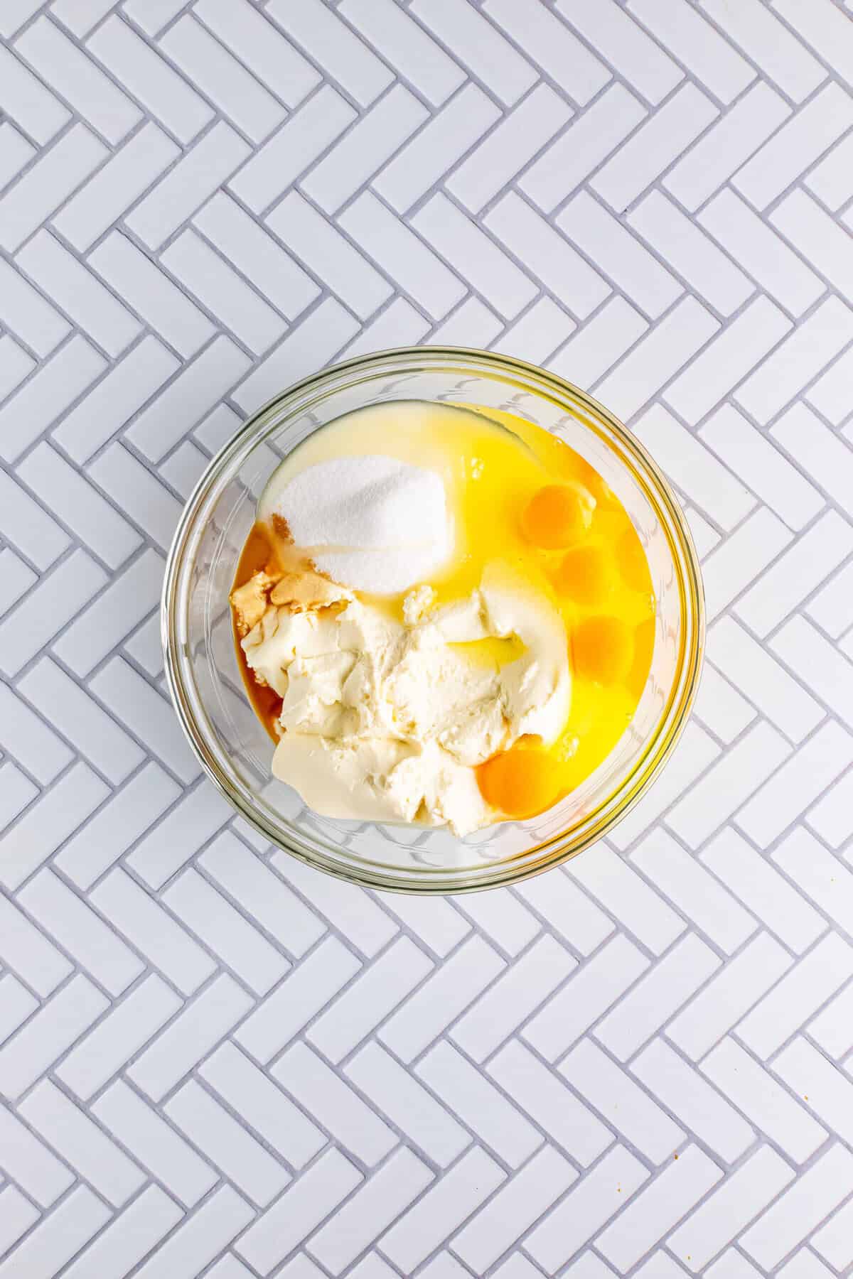 Ricotta cheese, eggs, sugar, and vanilla mixed in a glass bowl for the Italian Love Cake Recipe filling.