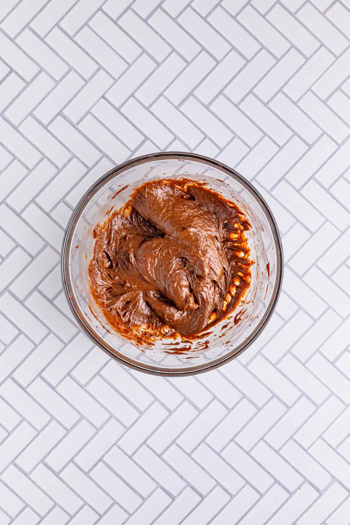 Cold milk and instant chocolate pudding mix being whisked together in a large bowl for the Italian Love Cake Recipe topping.