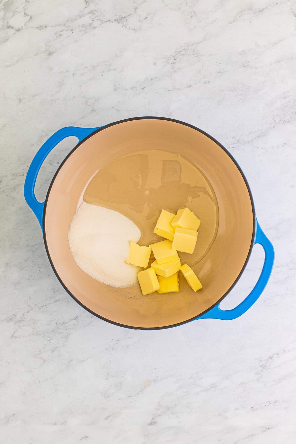Butter, corn syrup, and sugar melting together in a pot for caramel pecan logs.