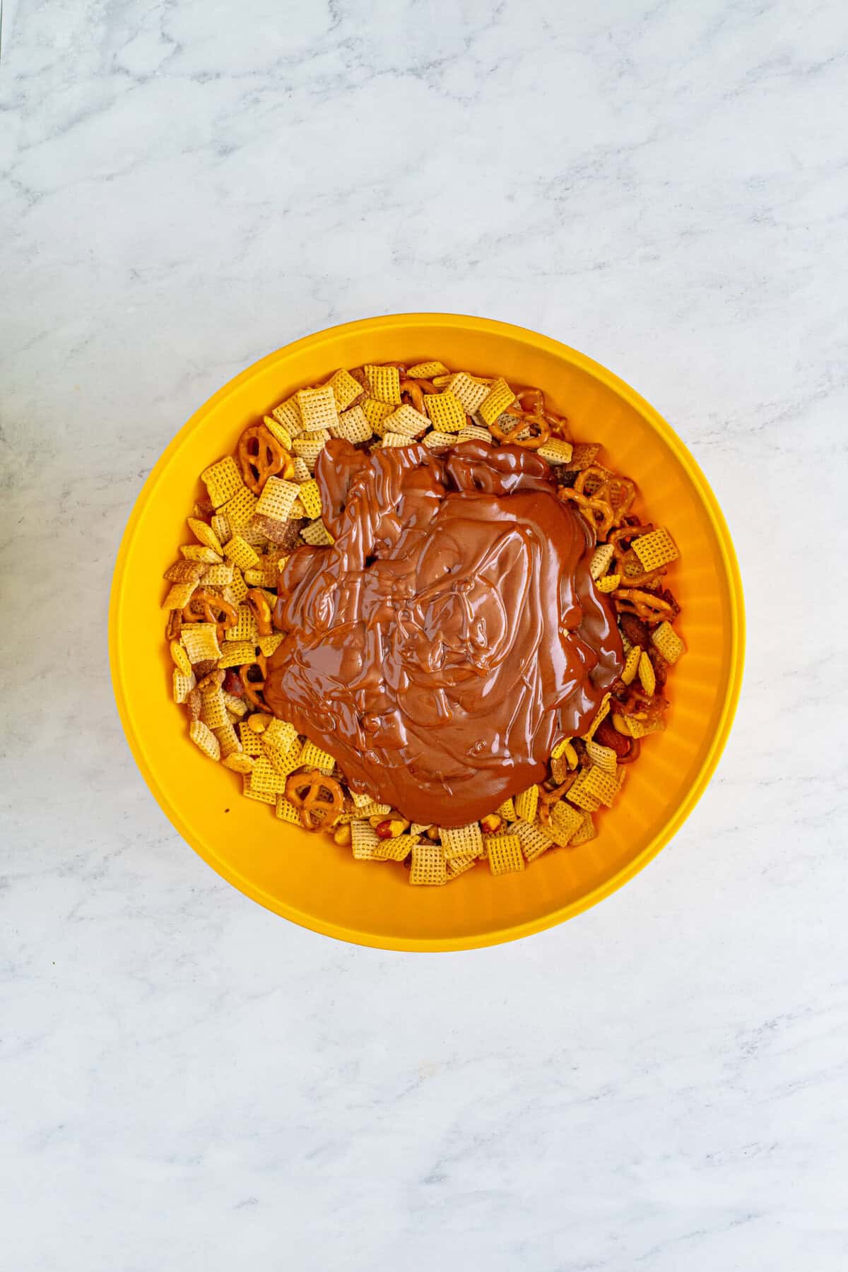 Melting peanut butter, butter, and chocolate together in an orange bowl.