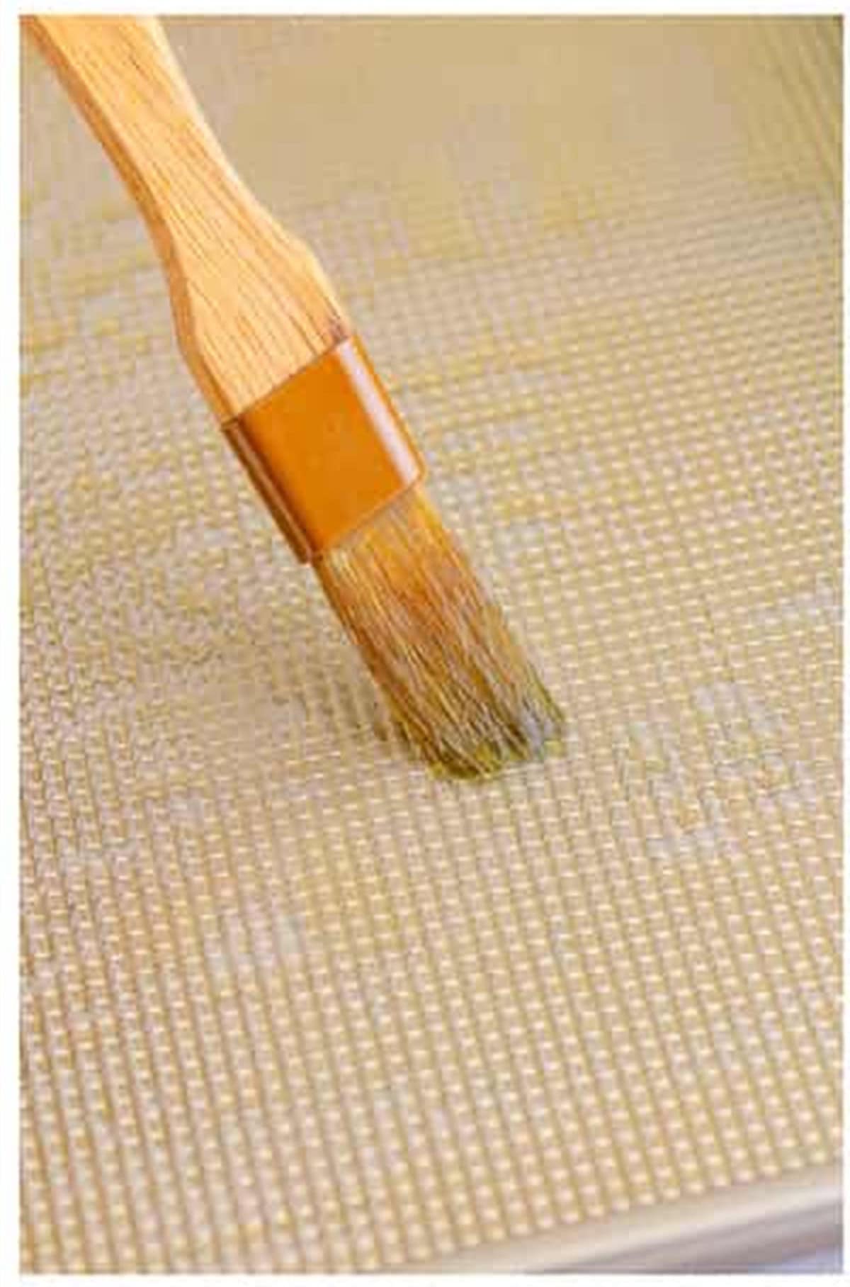 Pastry brush coating a sheet pan with olive oil for The Best Sheet Pan Pizza Recipe.
