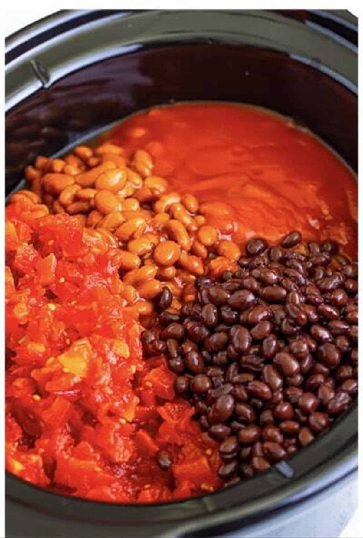 Diced tomatoes, beans, salsa, and sauce added to the beef in the slow cooker.