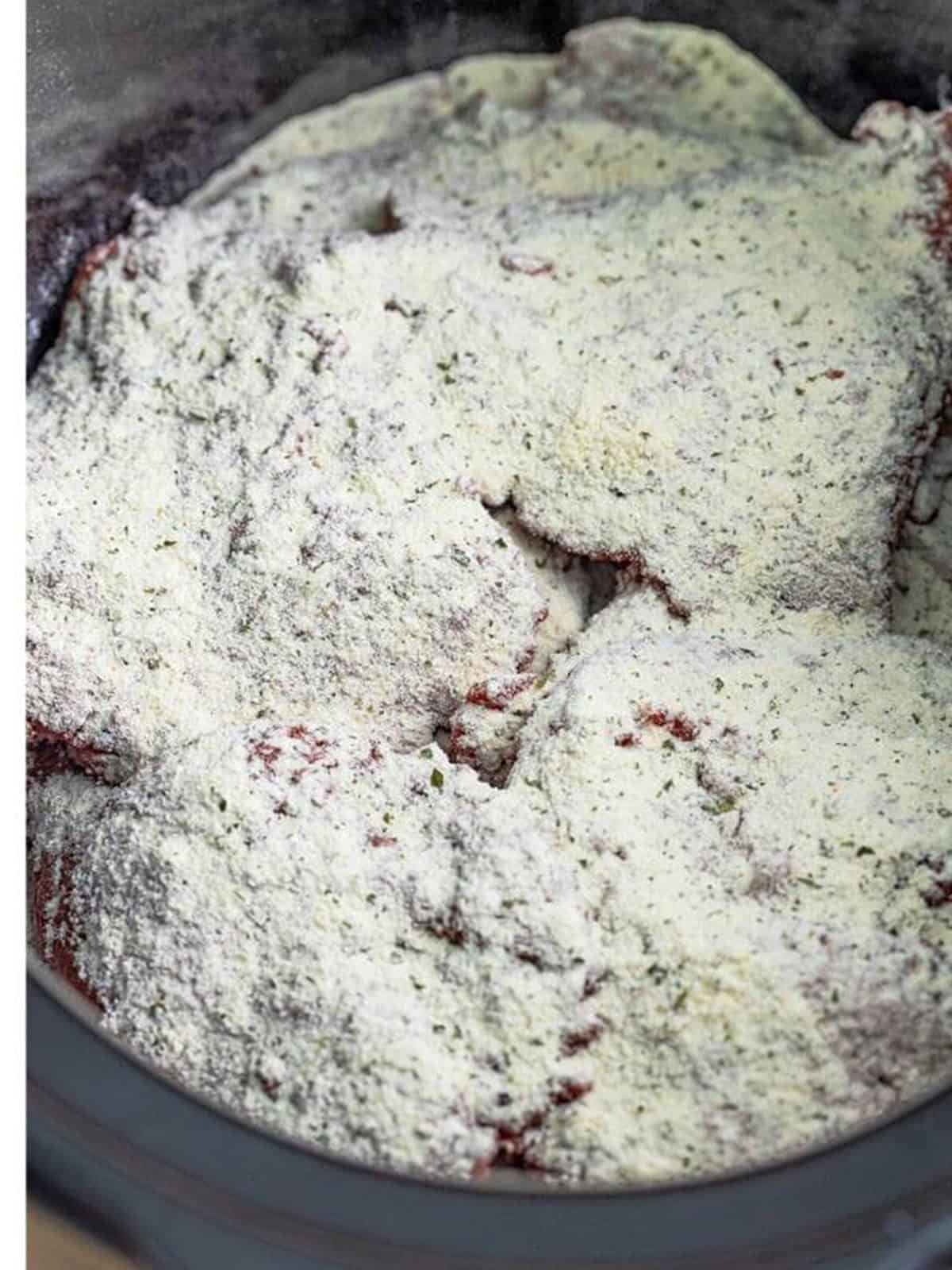 Ranch seasoning sprinkled over the cube steaks in the slow cooker.