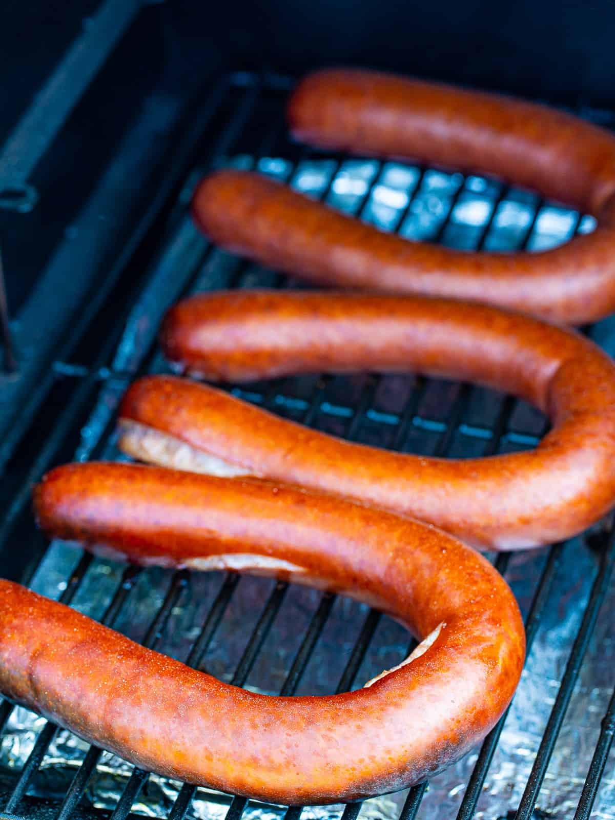 Browned smoked kielbasa coil on the grill.