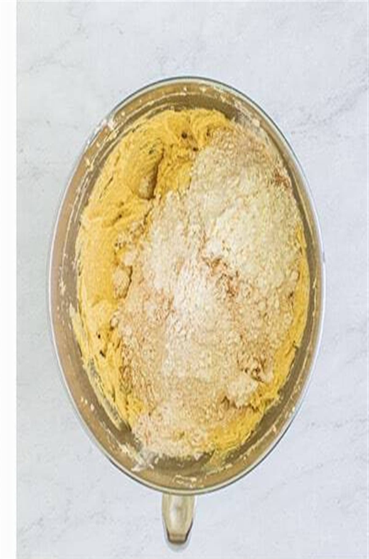 Eggs and flour mixture added to the creamed butter and sugar in the mixer bowl for Soft Chewy Oatmeal Raisin Cookies.