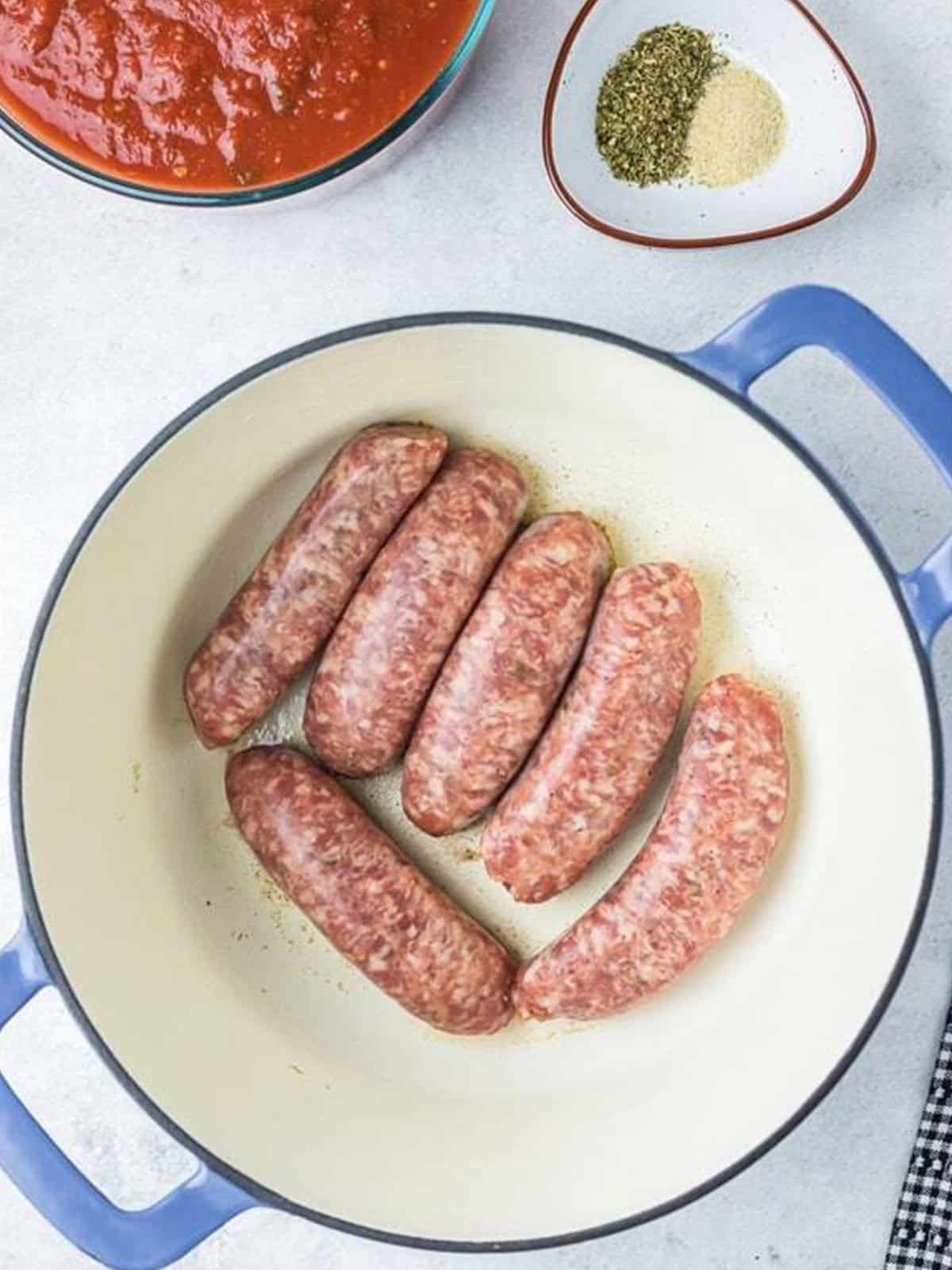 Italian sausage links browning in a Dutch oven for Spaghetti and Meatballs.