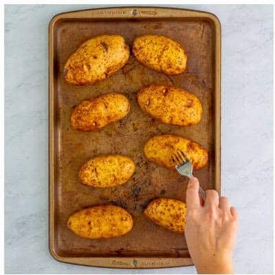 Russet potatoes baking on a sheet pan for the first hour at 400F for Loaded Potato Skins.