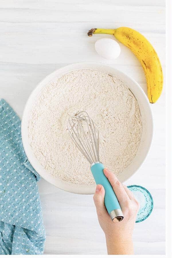 Whisking flour, sugar, baking powder, baking soda, salt, and cinnamon for the muffin dry mix.