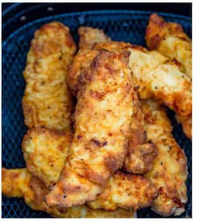 Cooked golden Air Fryer Buffalo Chicken Tenders fresh out of the air fryer basket.