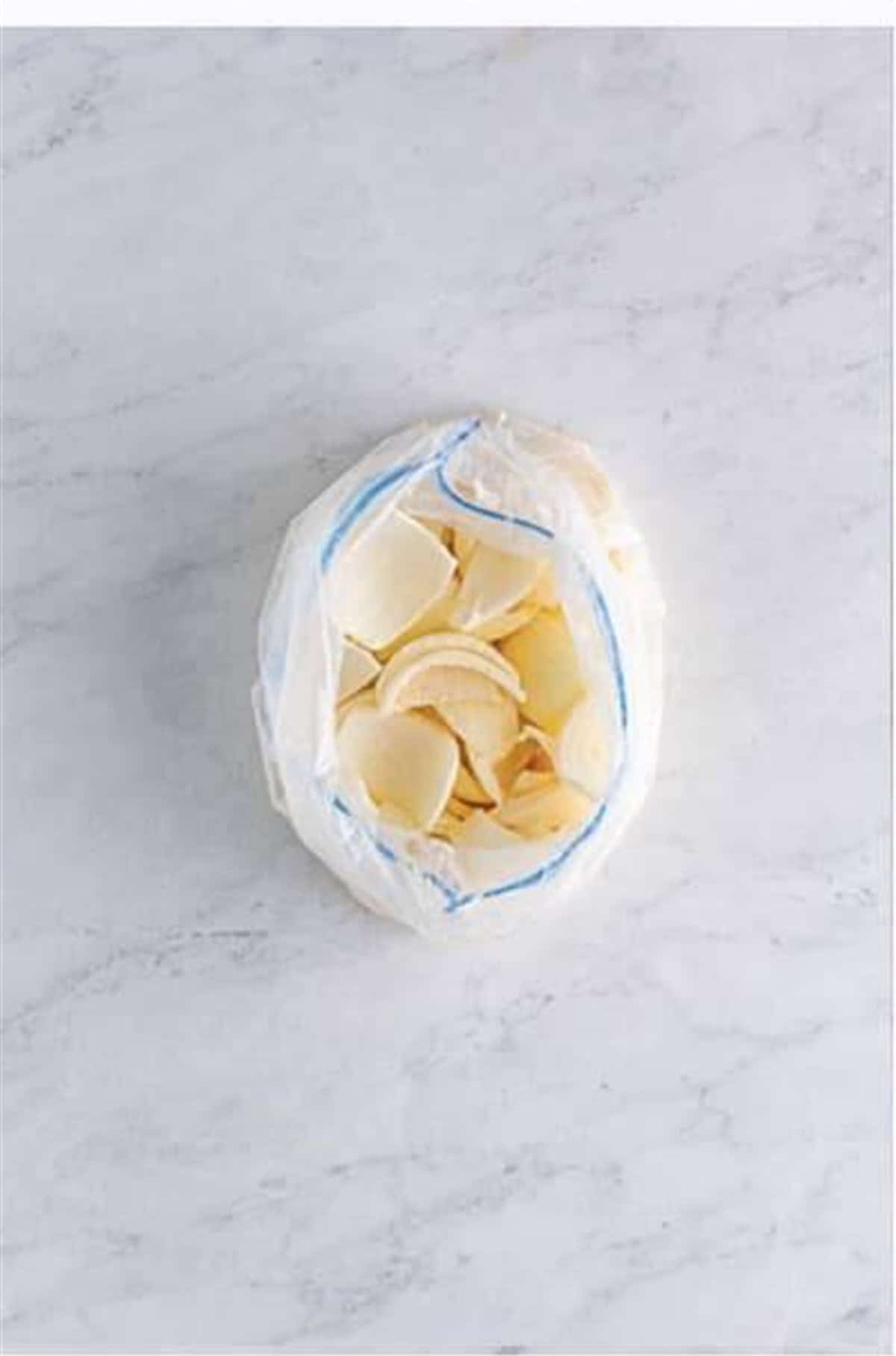 Toss sweet onion petals in seasoned flour to coat for Crispy Onion Petals Recipe.