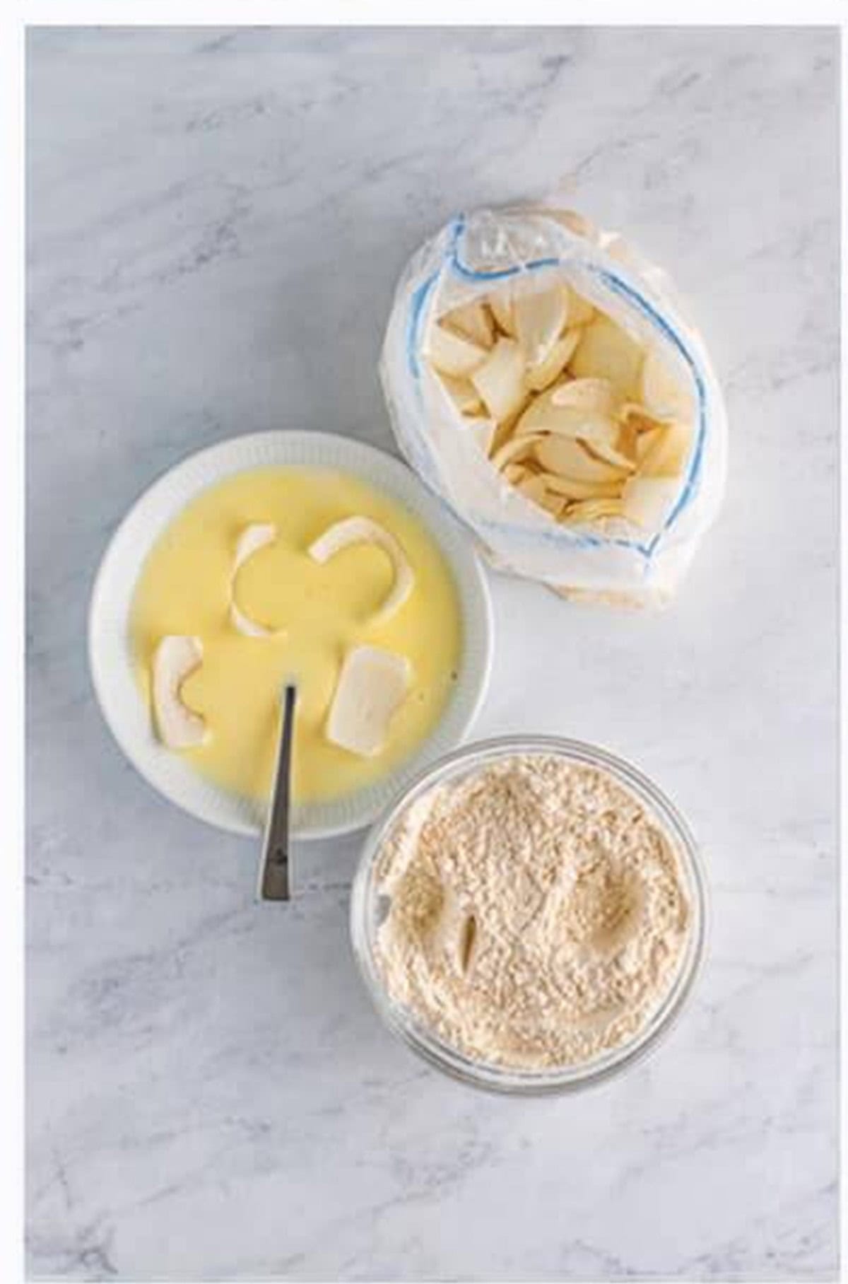 Dip floured petals into the buttermilk and egg wet batter for Crispy Onion Petals.