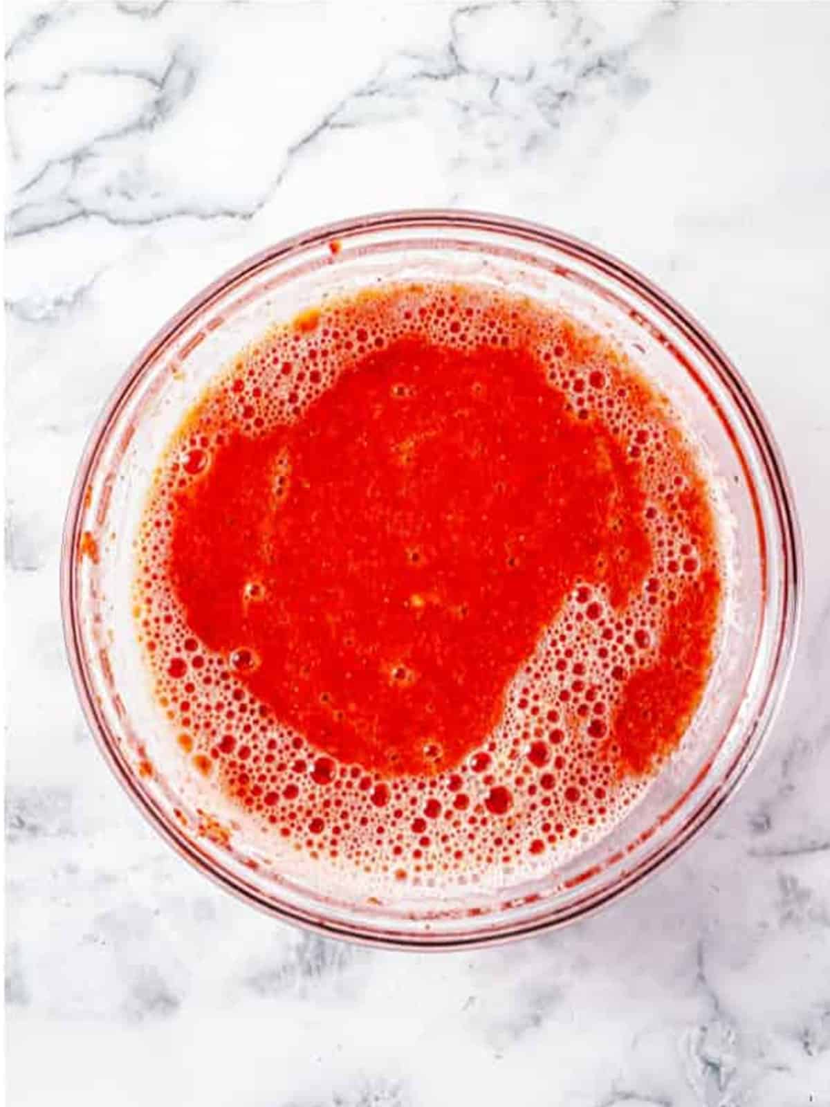 Pureed fresh strawberries in a glass bowl for strawberry butter.