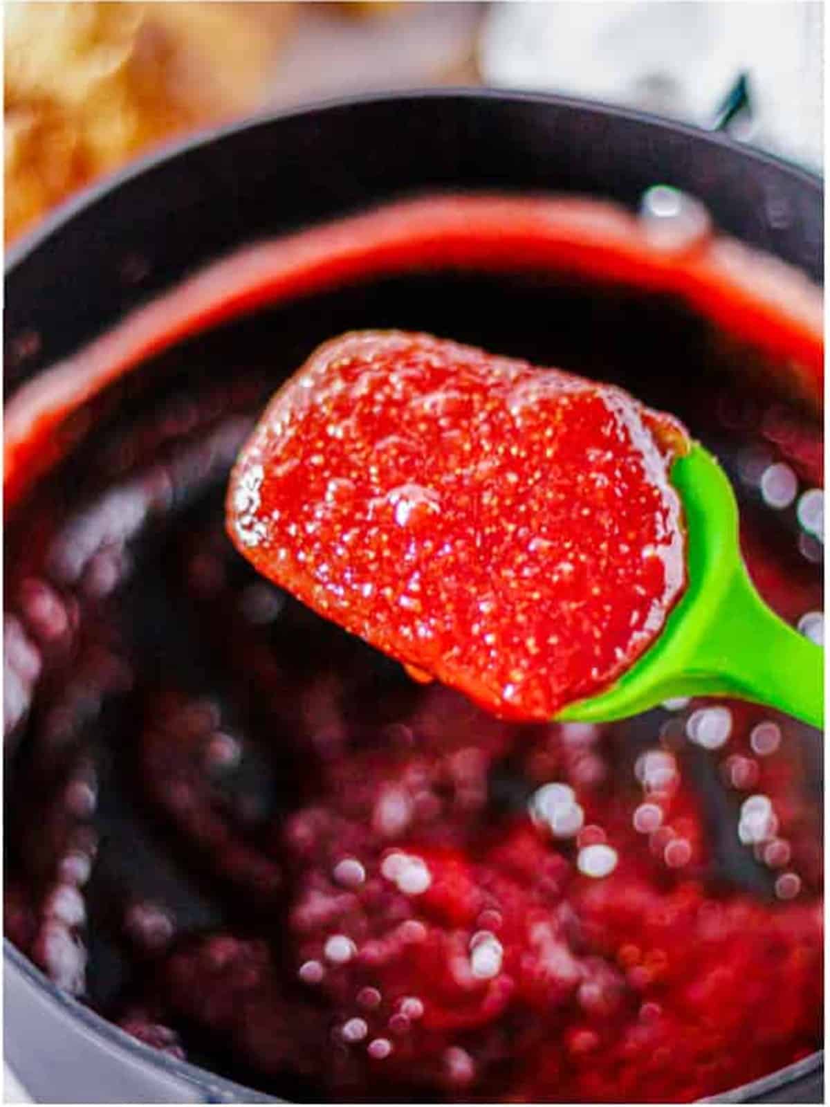 Thick finished honey strawberry butter on a spatula.